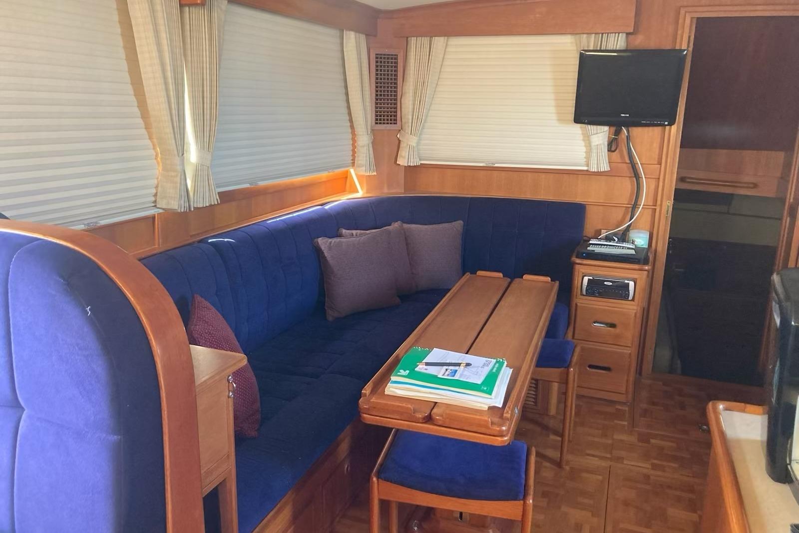 Interior of 2002 Grand Banks 42 Classic yacht with blue seating and wooden table.