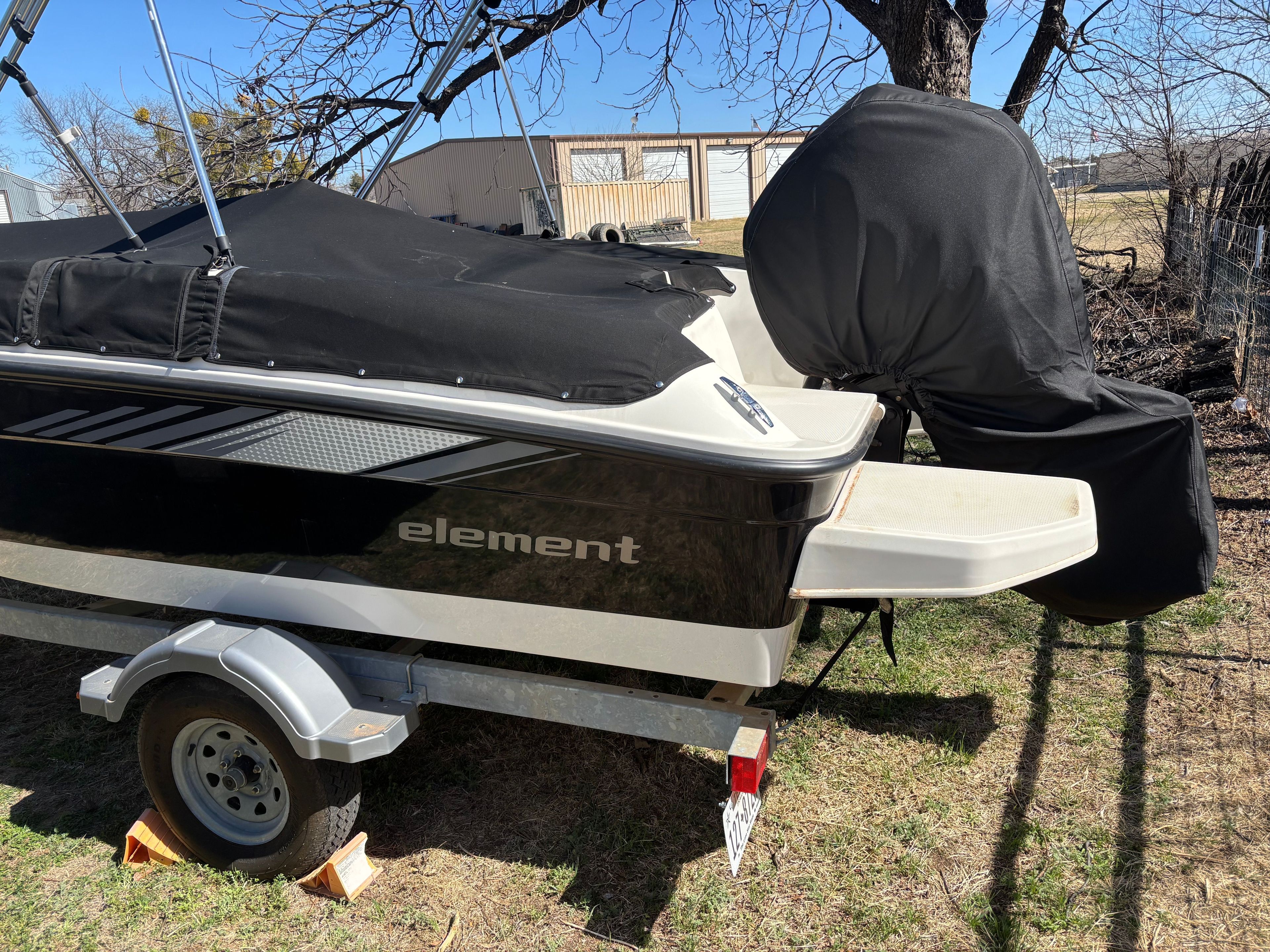 2025 Bayliner Element E18 boat with cover on trailer.