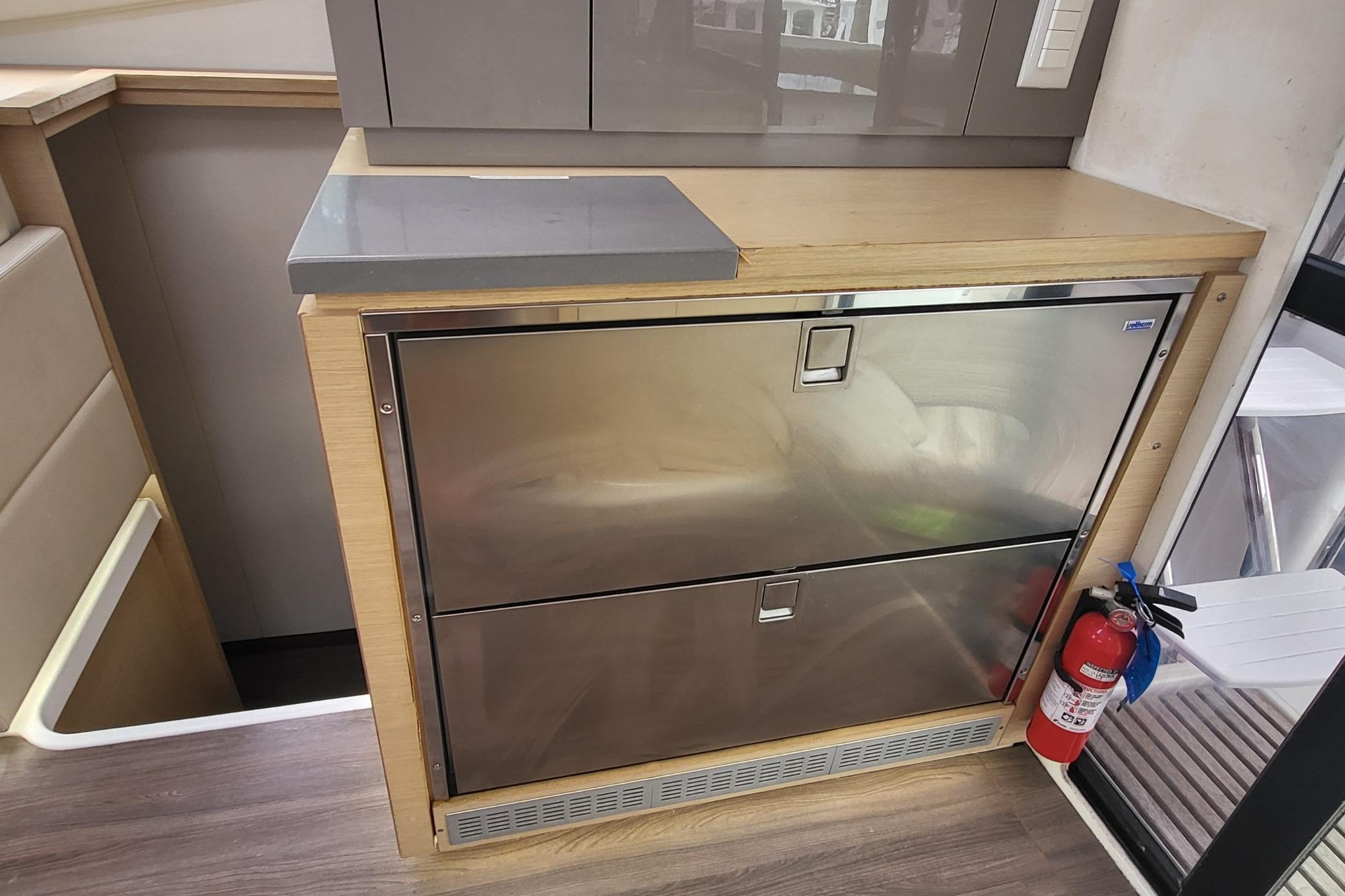 Interior of 2018 Fountaine Pajot Helia 44 with stainless steel drawers and fire extinguisher.