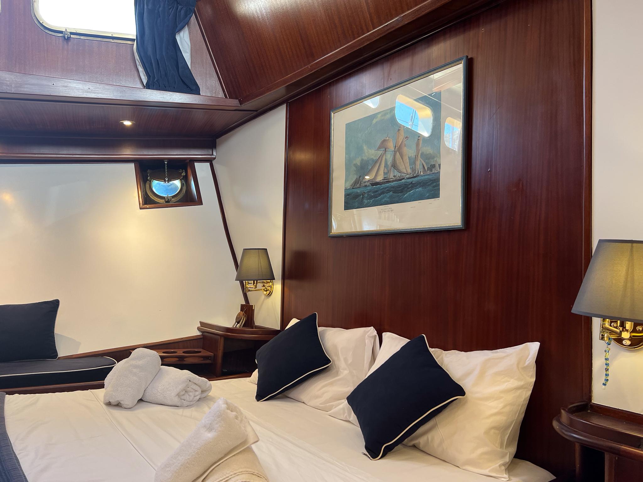 Luxurious cabin interior on a 1969 Psarros Shipyard yacht, featuring elegant wood paneling and nautical decor.