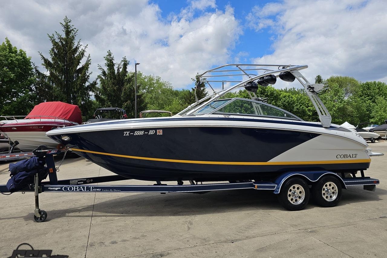 2010 Cobalt 232 WSS boat on trailer, parked outdoors under cloudy sky.
