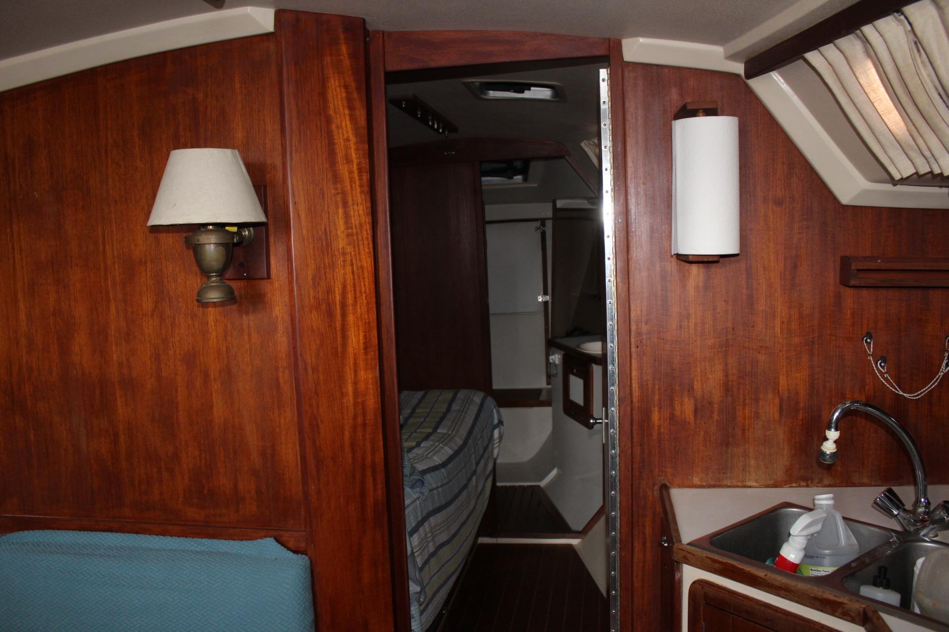Interior of 1989 Catalina 42 sailboat with wood paneling and compact kitchen area.