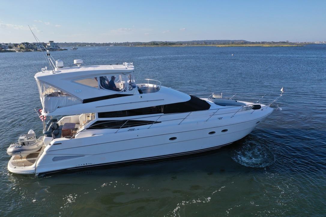 2005 Neptunus 56 Flybridge yacht cruising on calm waters under clear skies.