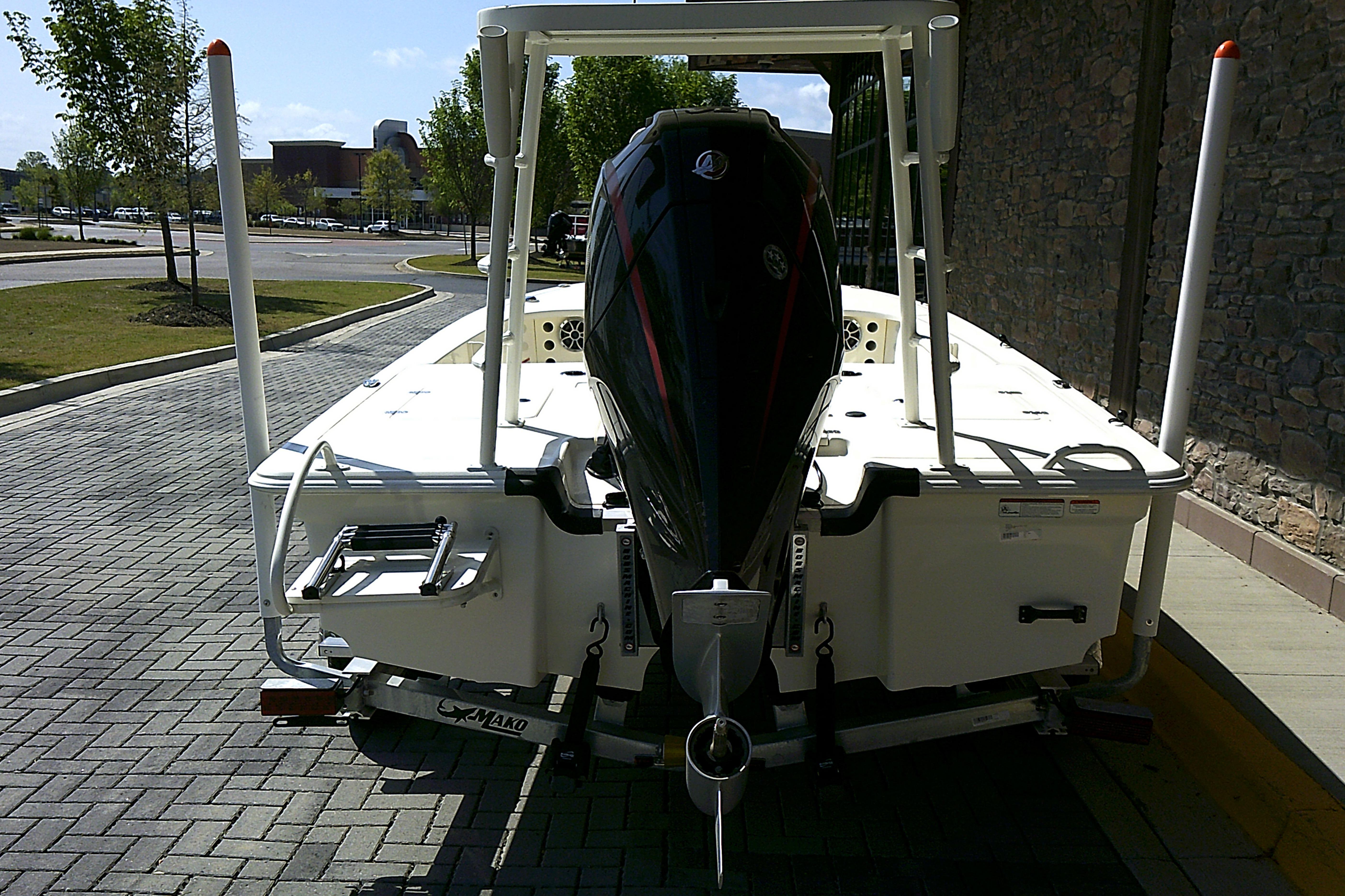 2026 Mako 18 Pro Skiff boat on trailer, rear view, parked outdoors.