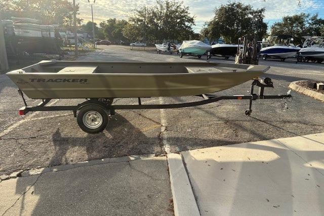 2026 Tracker Grizzly 1648 Utility boat on trailer in parking lot.
