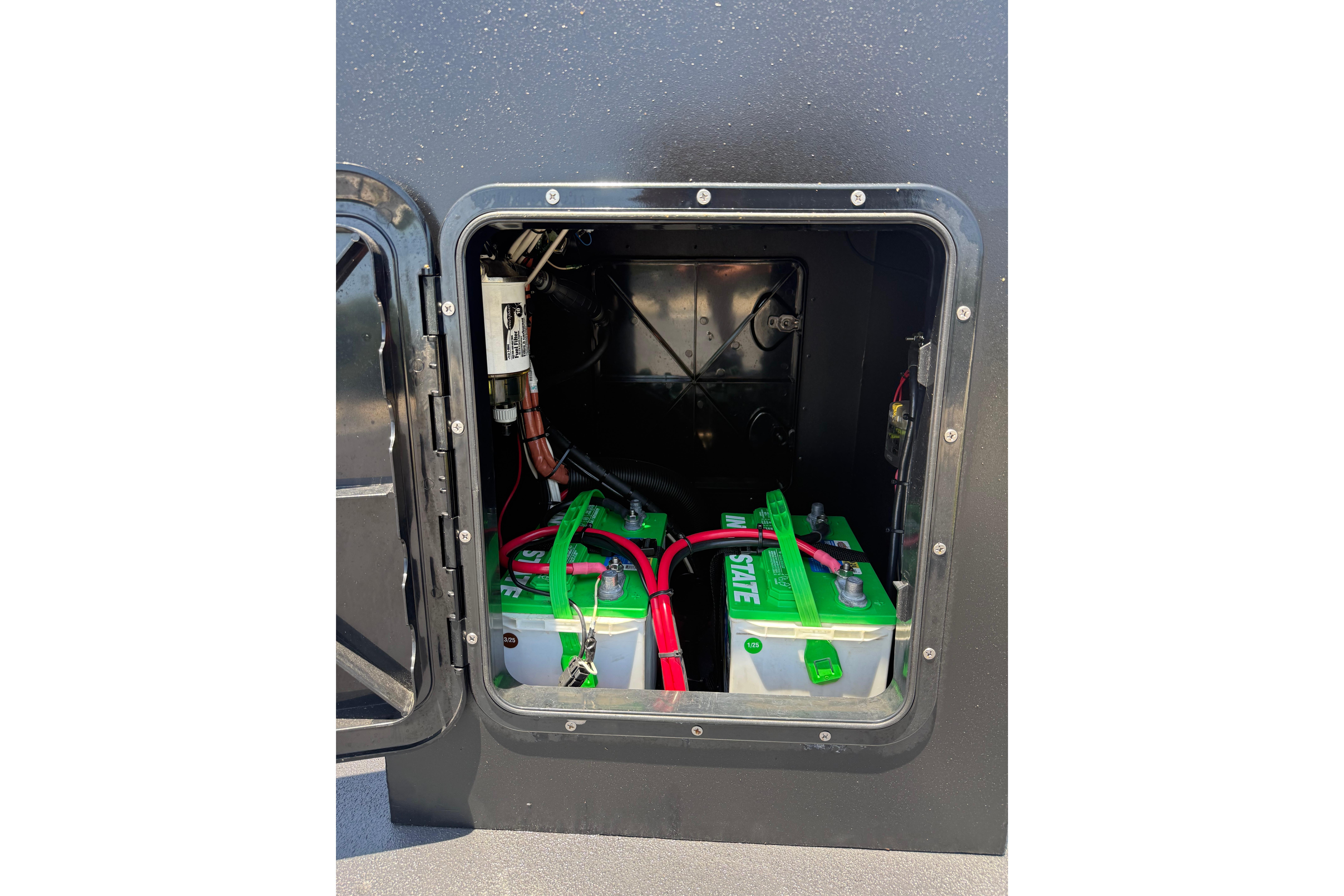 Battery compartment of Tough 20 model, 2026, featuring dual green batteries with red cables.