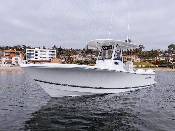 2025 Regulator 28 boat on calm water near coastal homes.
