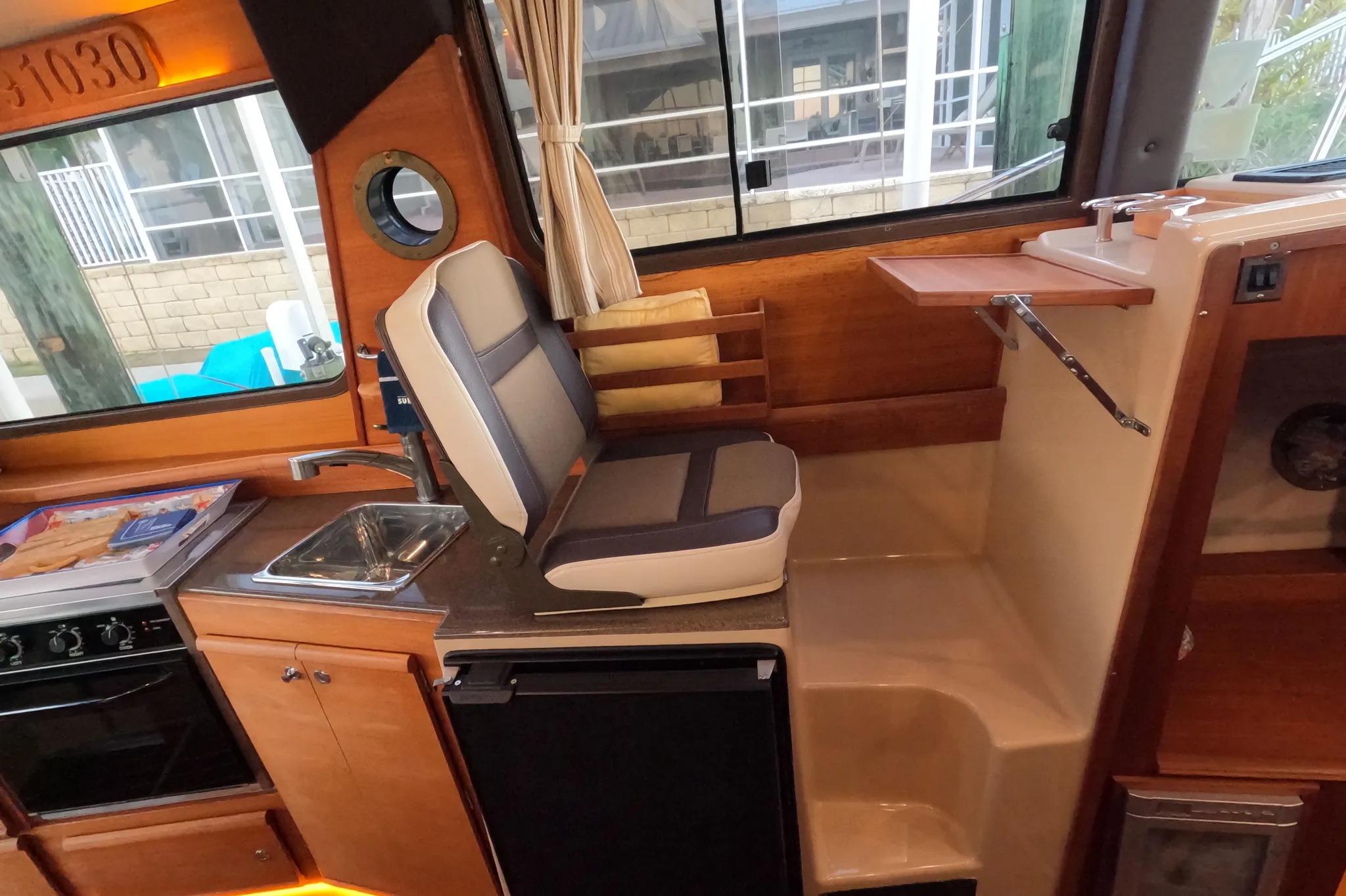 2015 Ranger Tugs R-29 S interior with compact kitchen and seating area.