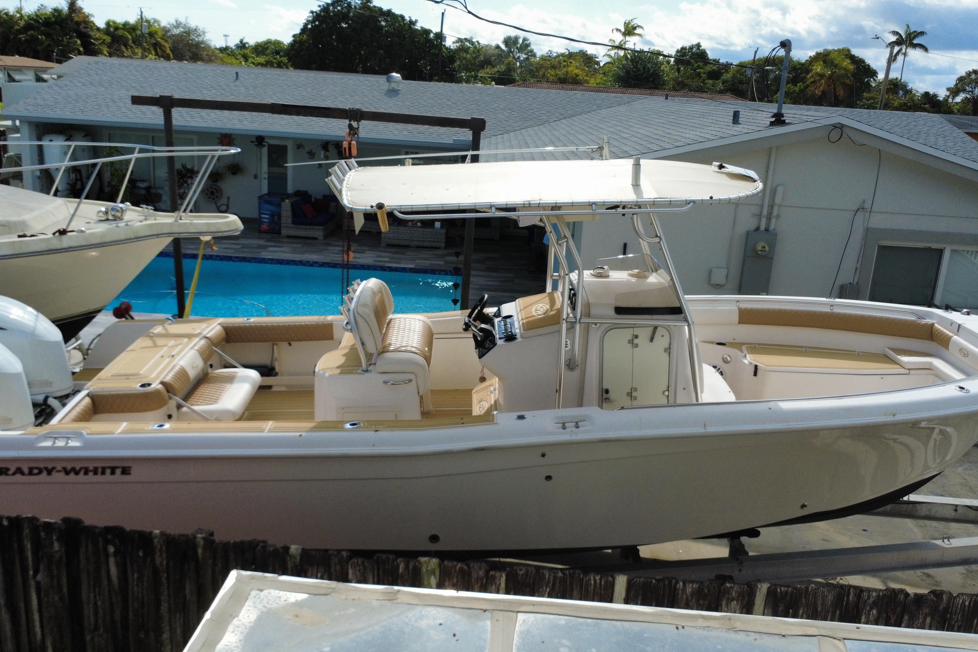 2004 Grady-White Canyon 283 boat docked near a pool, showcasing its spacious deck.