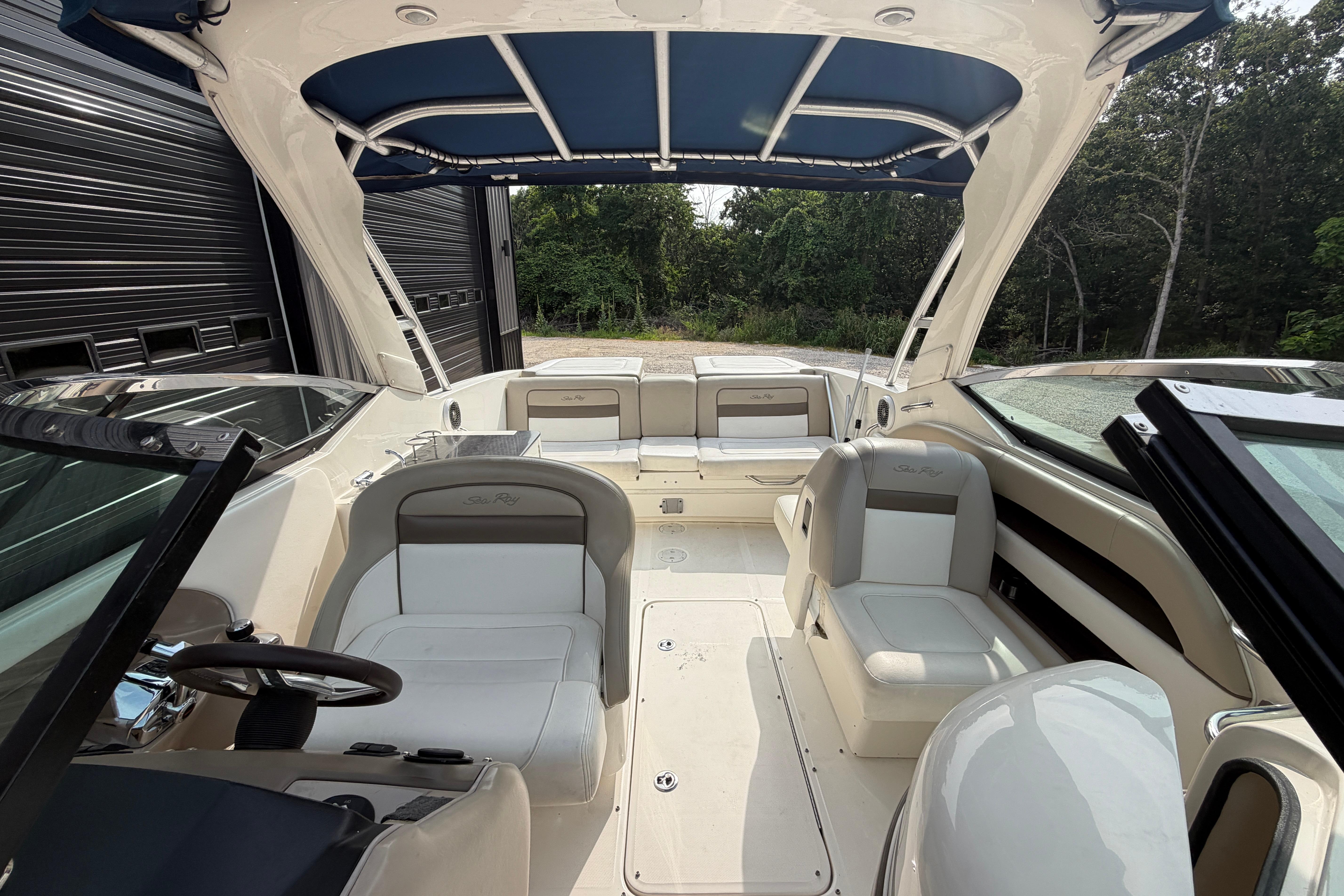 Interior view of a 2013 Sea Ray 300 SLX boat with seating and canopy.
