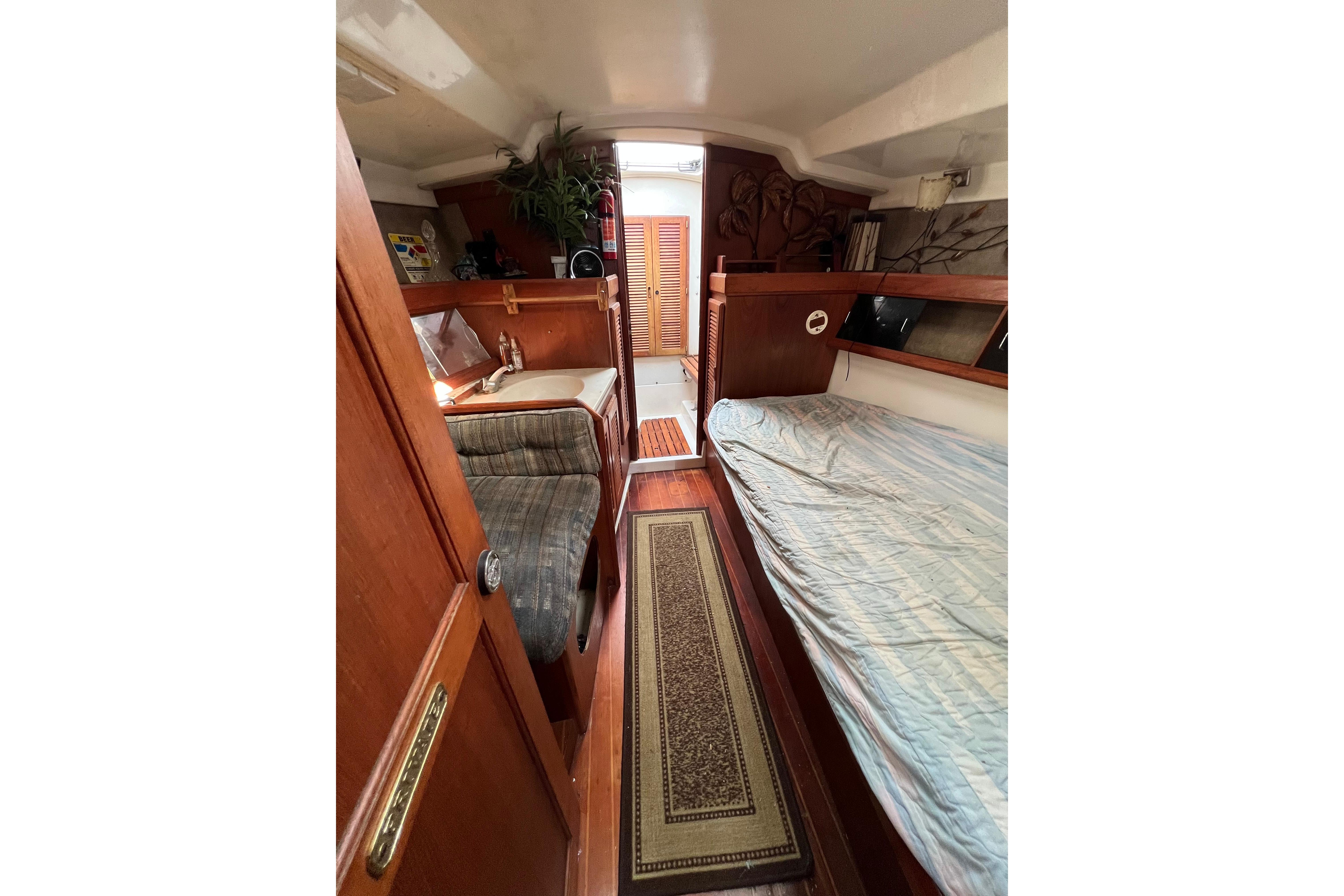 Interior of 1986 Hunter Legend 45 sailboat with cozy wooden furnishings and bedding.