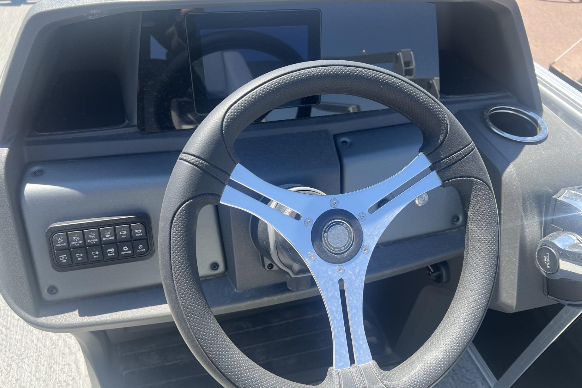 Steering wheel of 2026 Sun Tracker Fishin' Barge 20 DLX boat, featuring control panel.