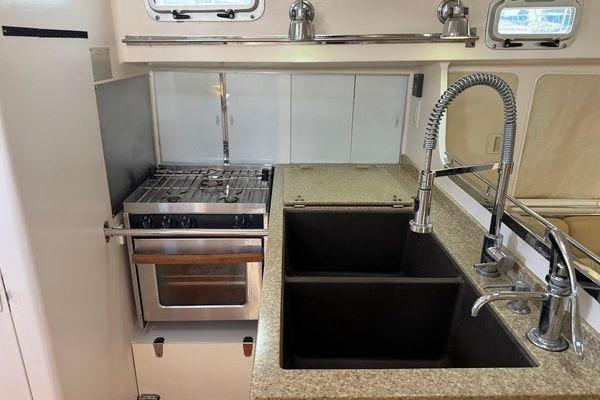 Modern kitchen area in a 2011 Reliance 44 yacht with dual sinks and stove.
