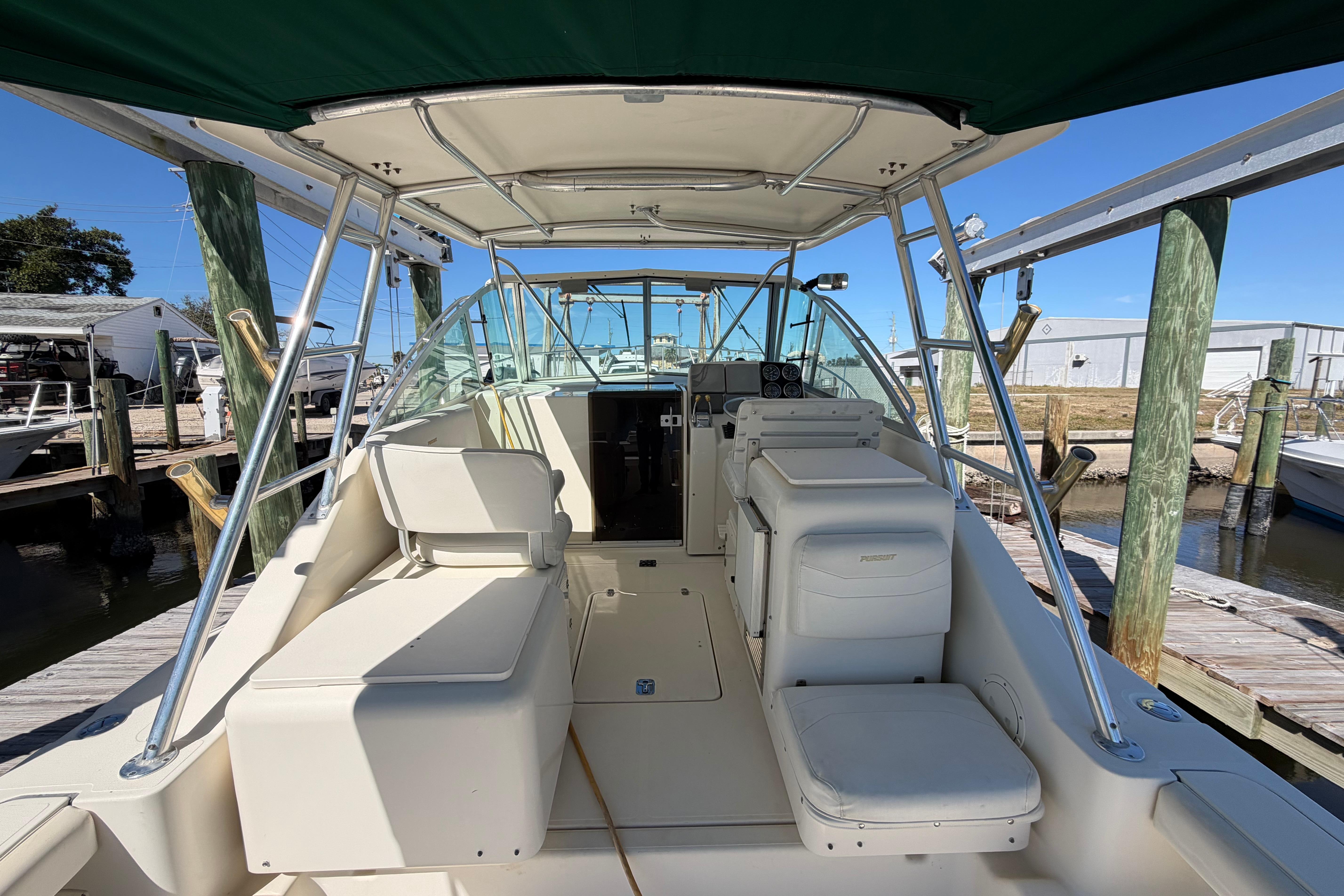 2001 Pursuit 3000 Express boat interior with seating and helm, docked at marina.
