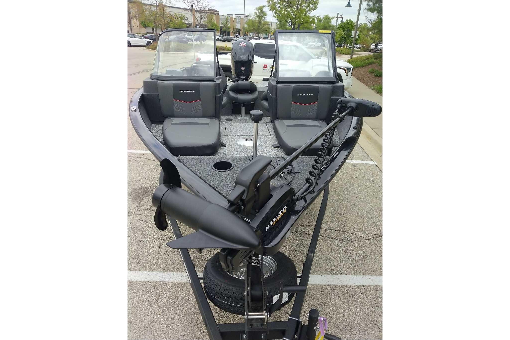2026 Tracker Pro Guide V-175 Combo boat with dual windshields and trolling motor in parking lot.