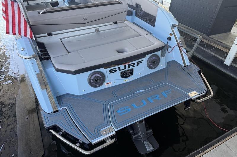 2026 Cobalt R8 Surf boat with American flag, featuring spacious seating and sleek design.