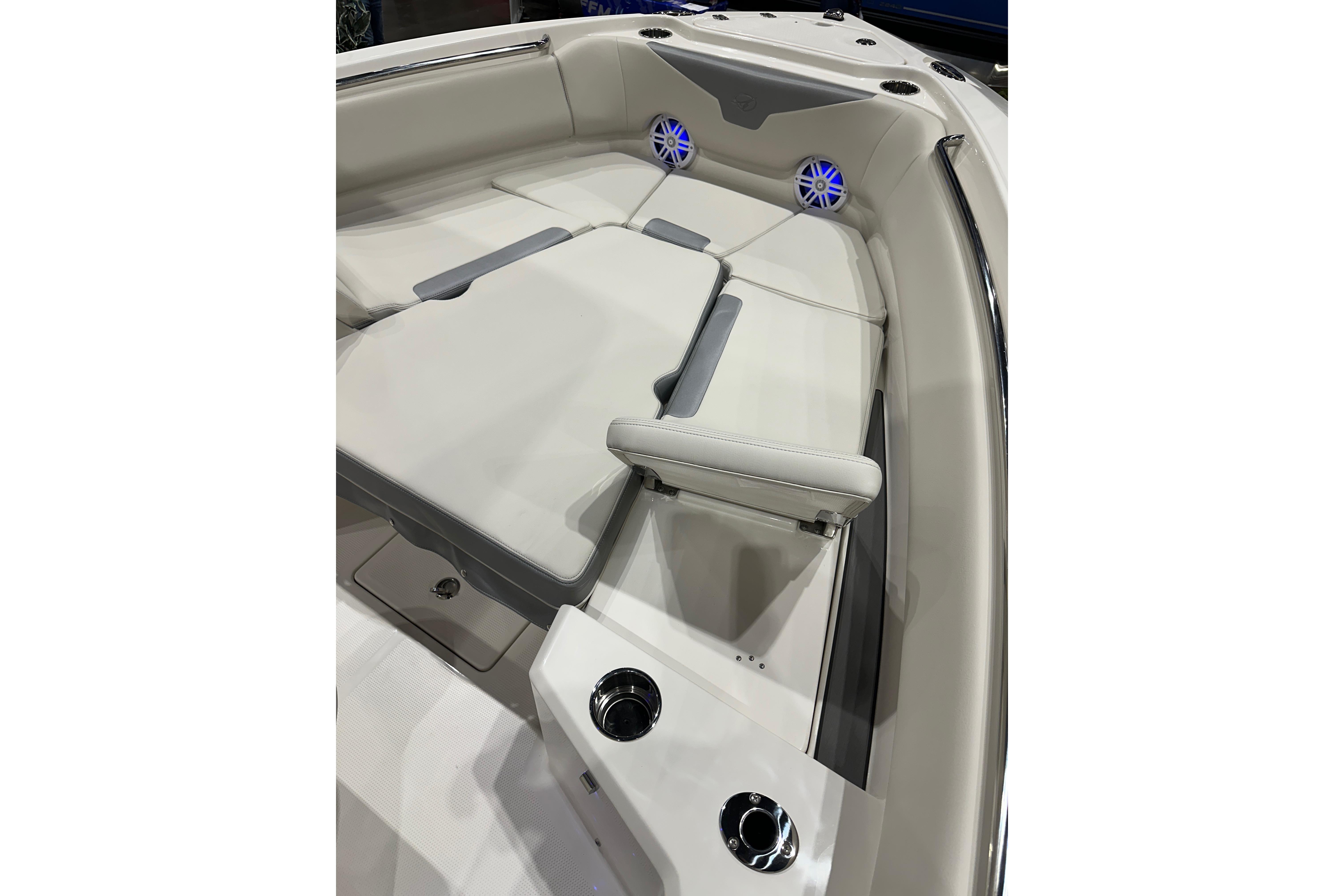 Luxurious seating area on 2026 Sailfish 232 CC boat with cup holders and speakers.