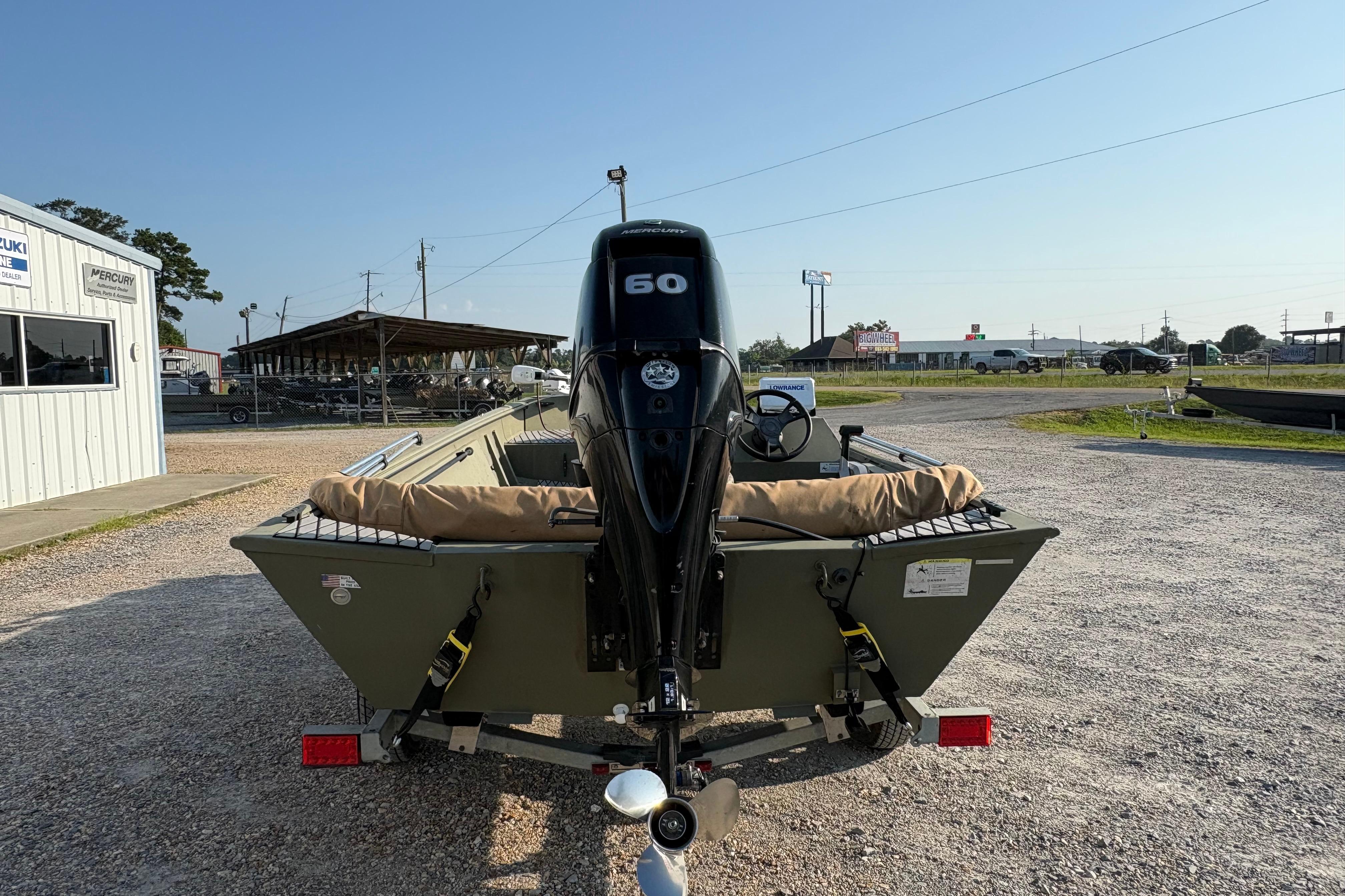 2019 Lowe Roughneck 1860SC boat with 60HP engine, parked outdoors on gravel.