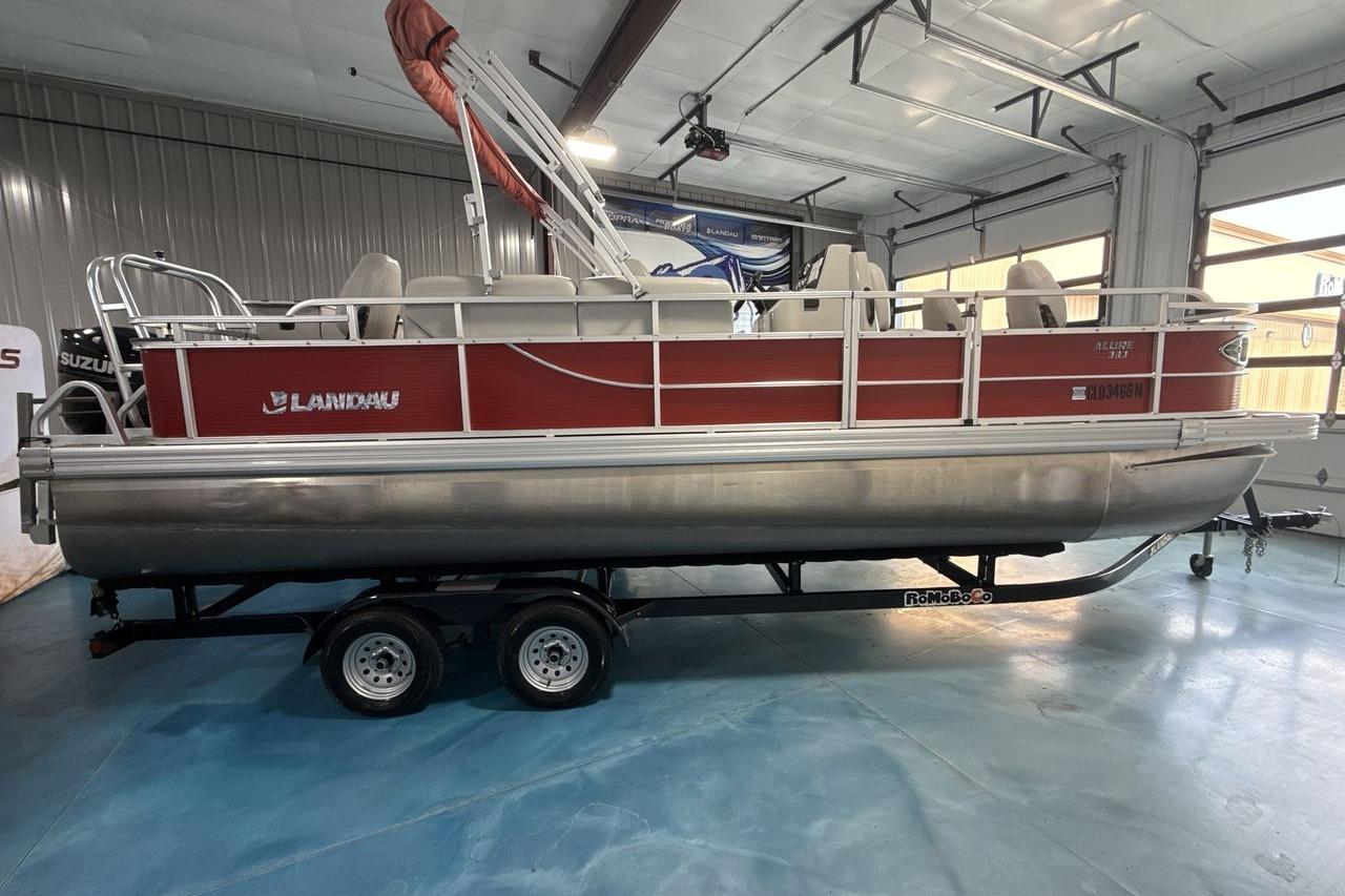 2022 Landau ALURE 232 pontoon boat in a showroom, red exterior, on a trailer.