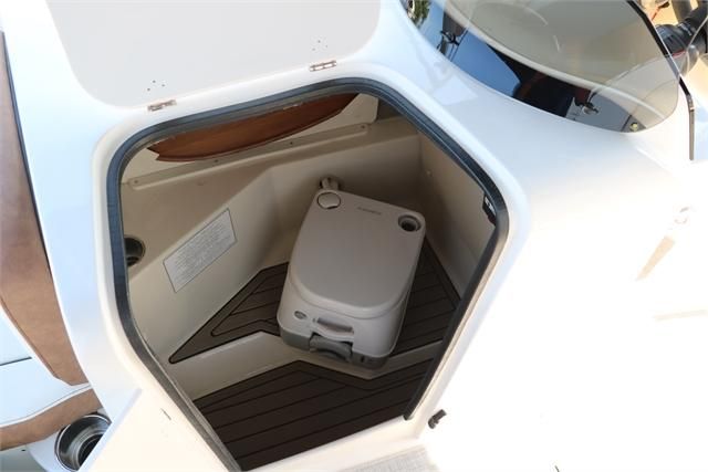 The image shows the interior of a boat with a portable toilet and wooden flooring.