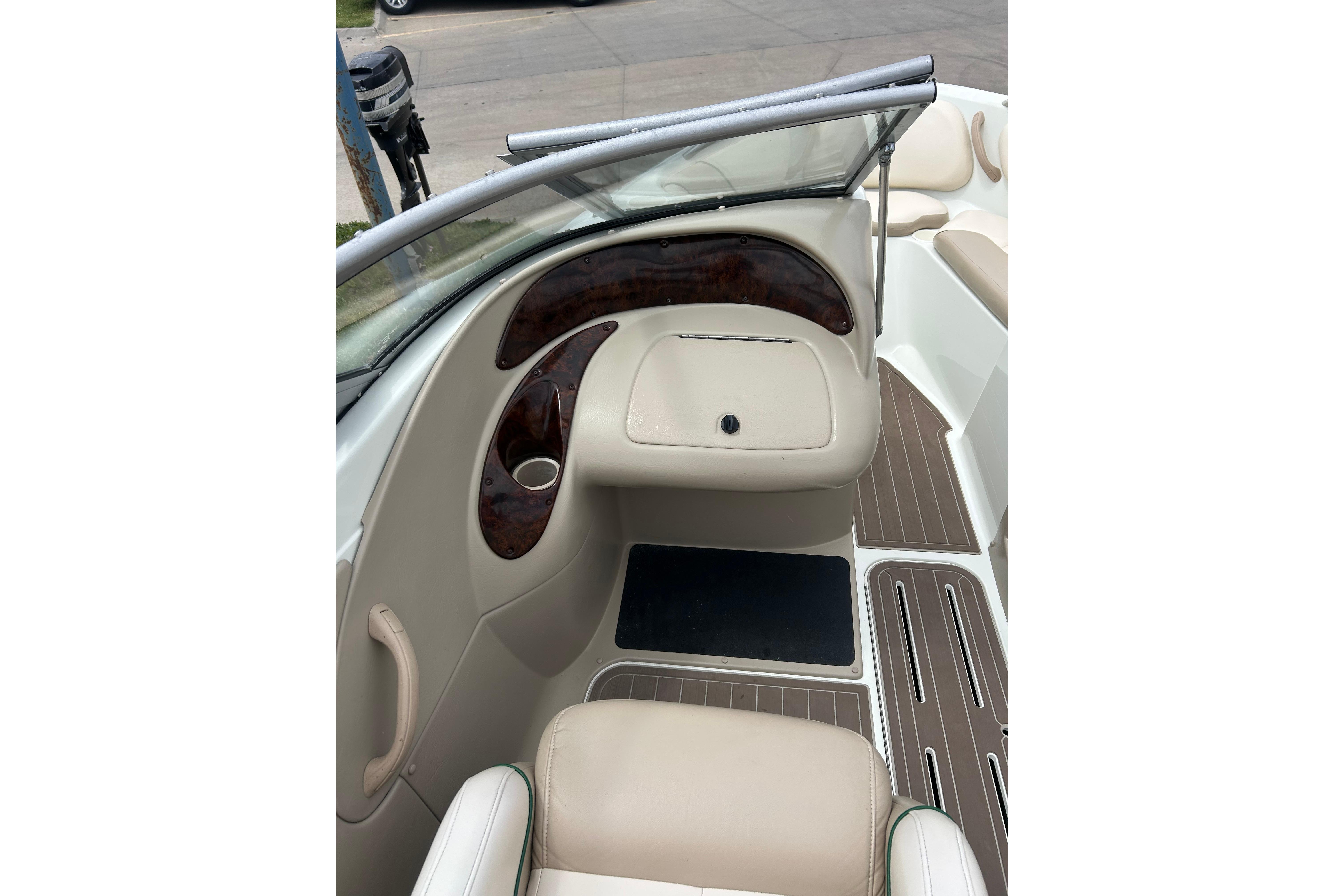 Interior view of a 2000 Starcraft 1810 boat, featuring beige seating and wood accents.