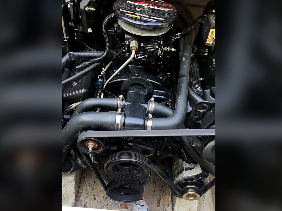 Engine compartment of a 1999 Maxum 2300CC with visible hoses and belts.