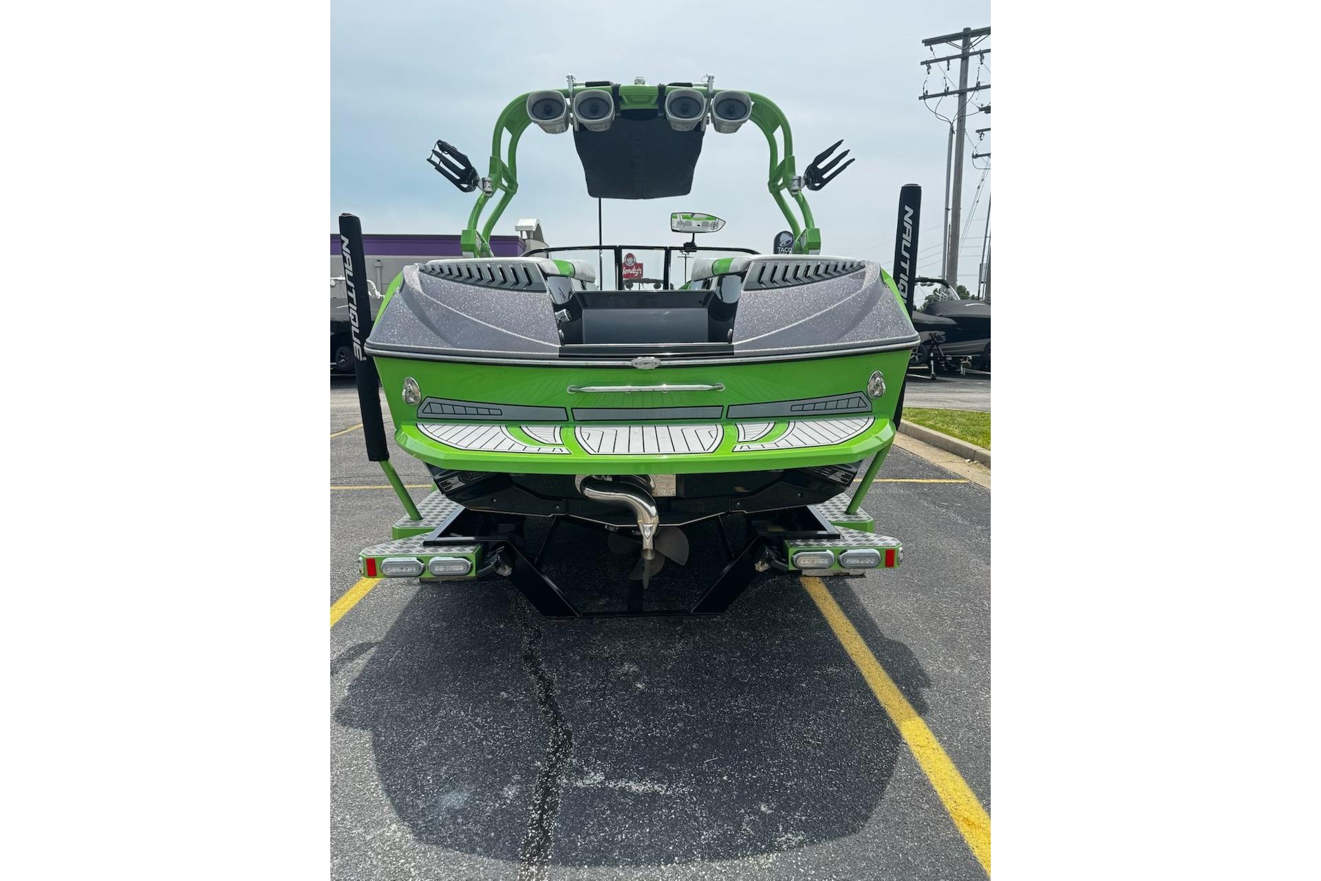 2014 Nautique Super Air Nautique G21 boat, green exterior, rear view in parking lot.