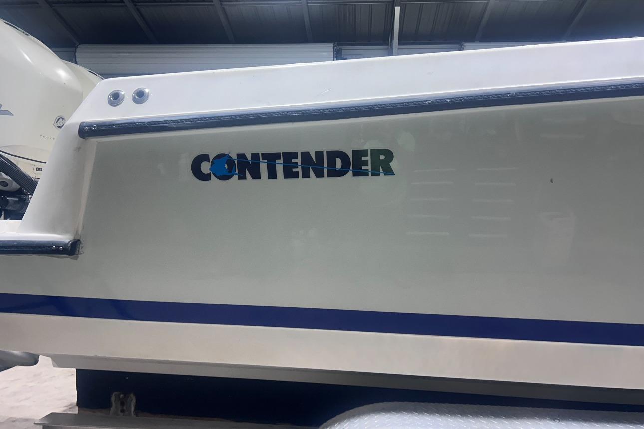 2005 Contender 35 ST boat side view with logo in a garage setting.