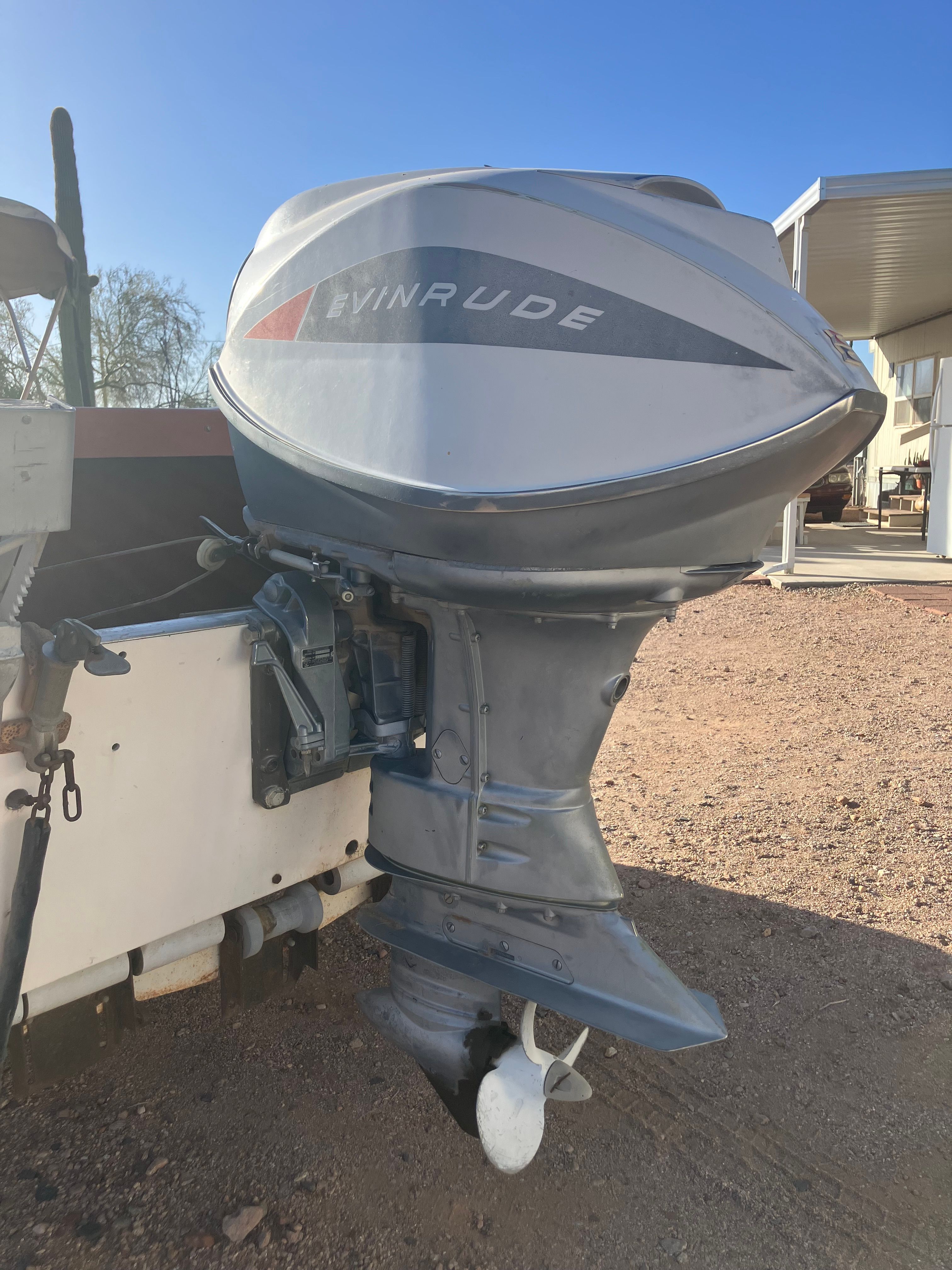 An Evinrude outboard motor attached to a boat on dry land.