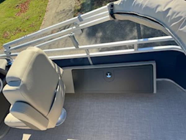 Interior of 2025 Sun Tracker Fishin' Barge 22 DLX with seat and storage.