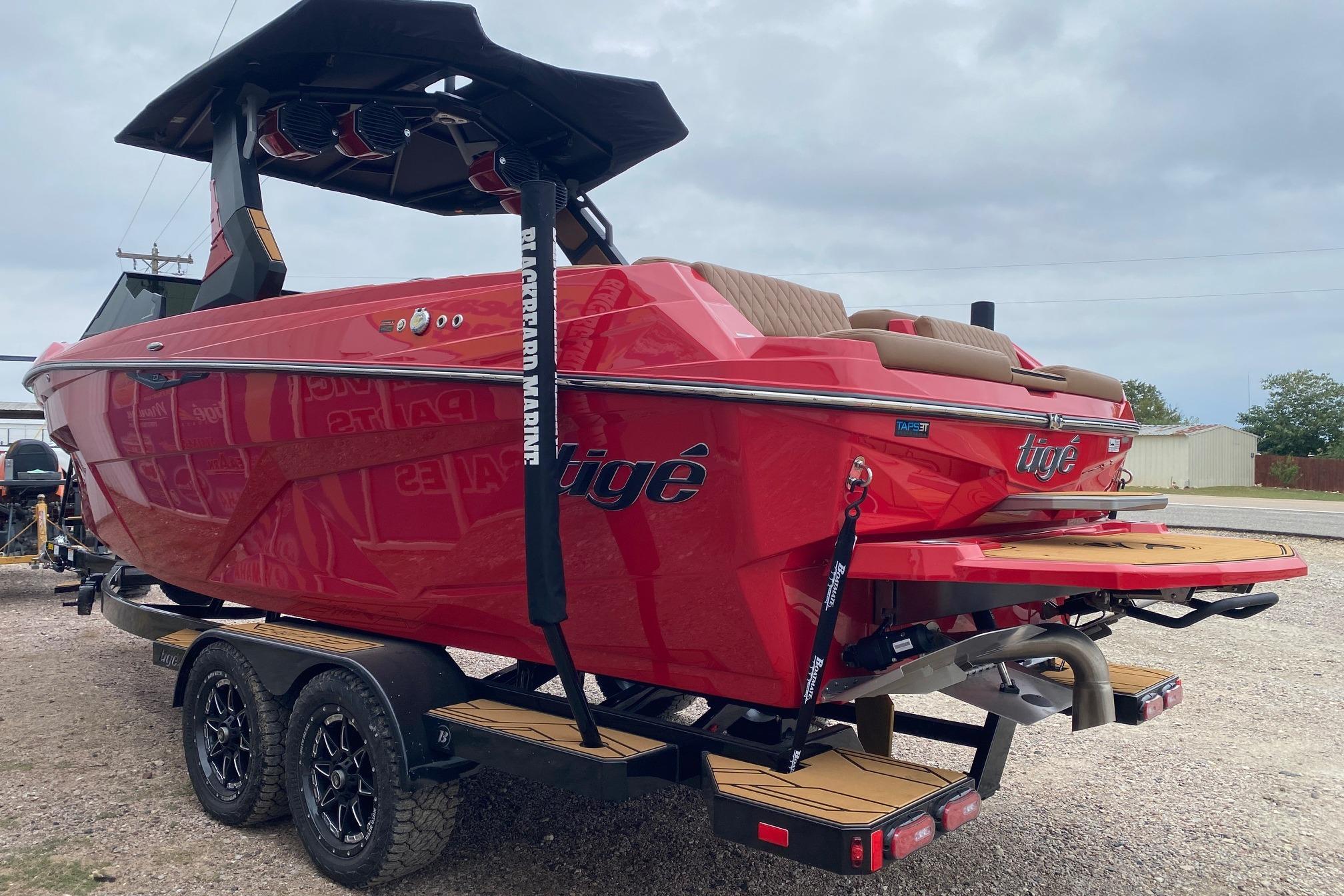 2026 Tigé Z3 boat in vibrant red on a trailer, showcasing sleek design and modern features.