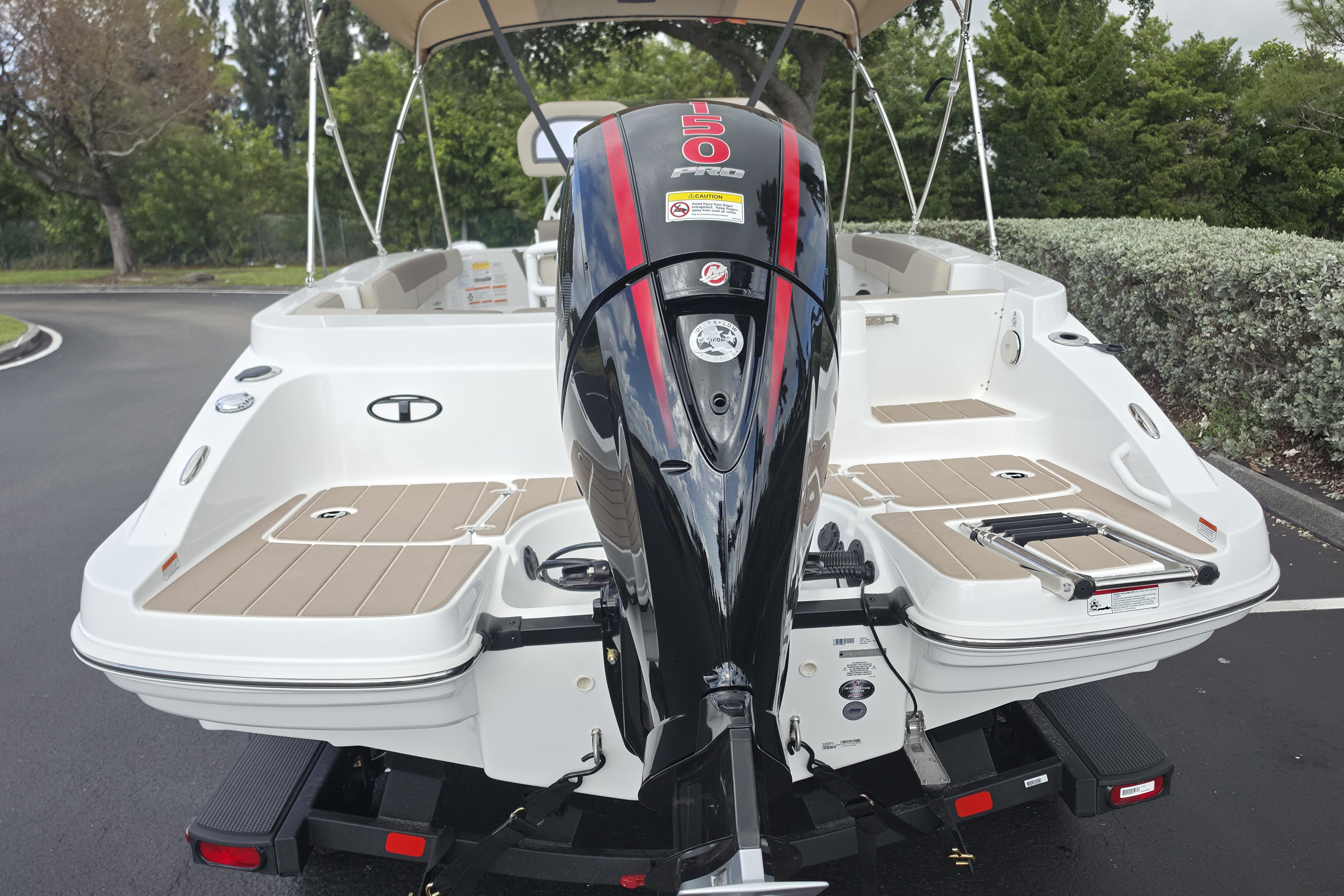2026 Tahoe 2150 CC boat with powerful outboard motor, parked on a paved surface.