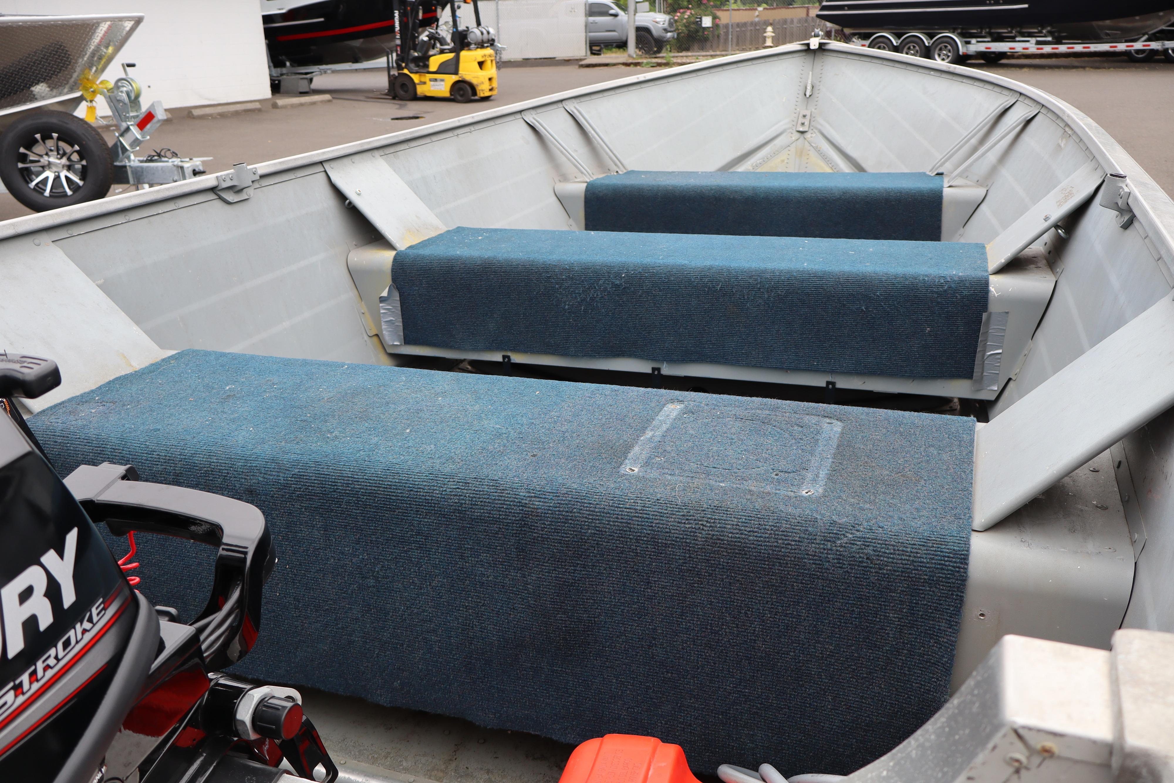 2003 Smoker Craft Alaskan 13 boat interior with blue carpeted benches.