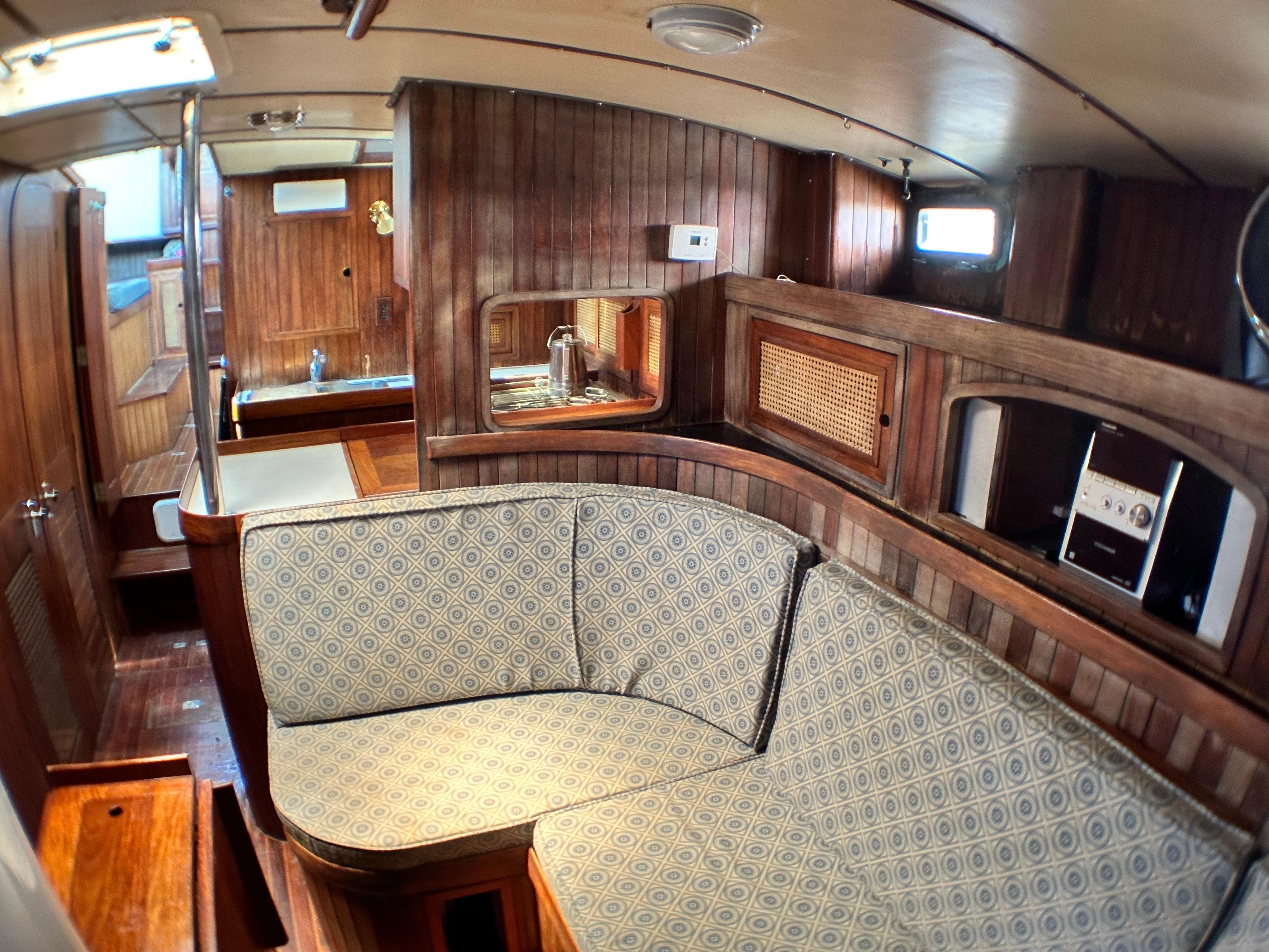 Interior of 1982 Pan Oceanic 43 sailboat with wooden paneling and patterned seating.