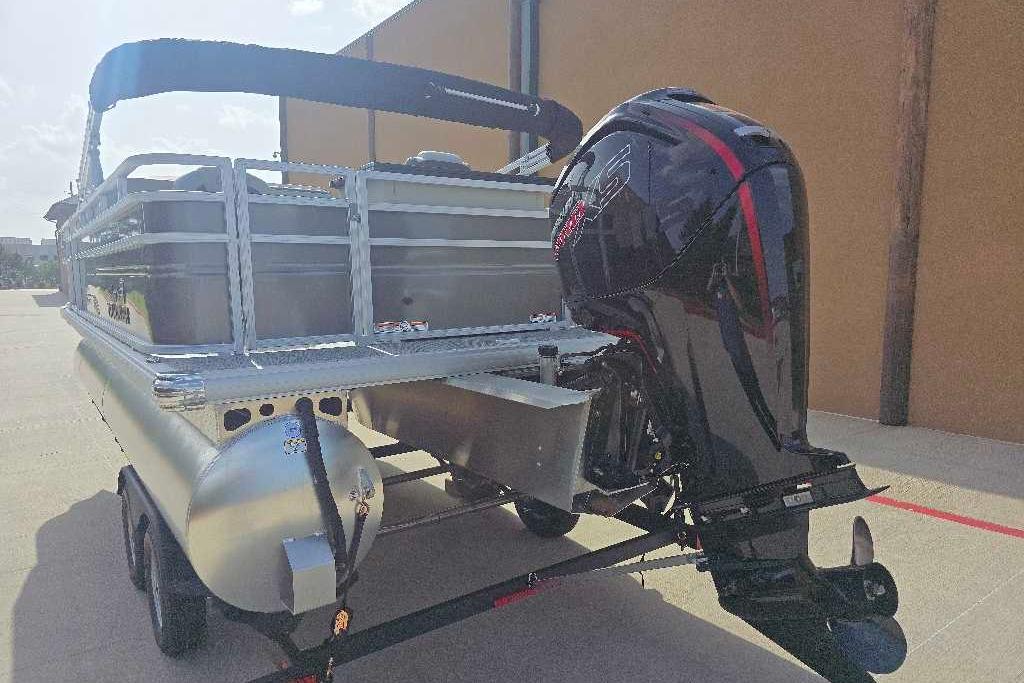 2026 Sun Tracker Fishin' Barge 20 DLX pontoon boat with powerful outboard motor.