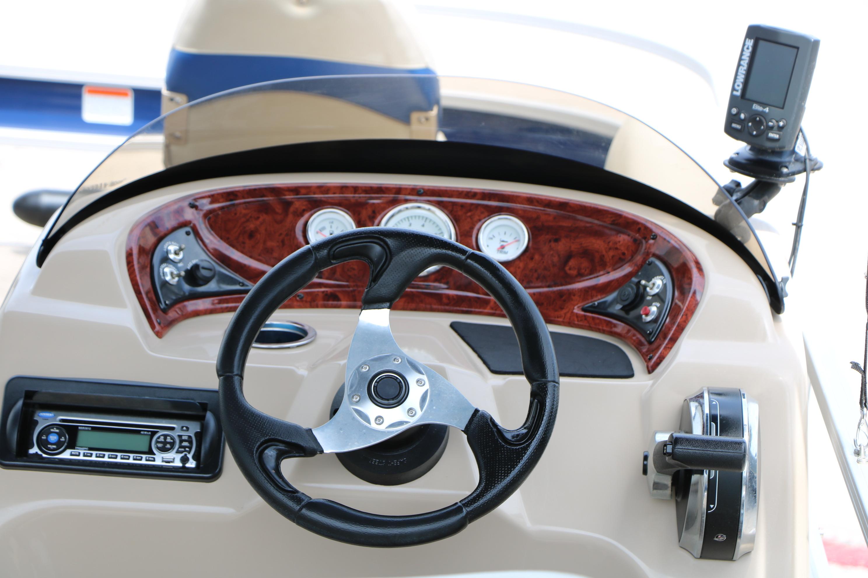 Steering console of 2013 Sun Tracker Fishin' Barge 20 DLX with gauges and controls.