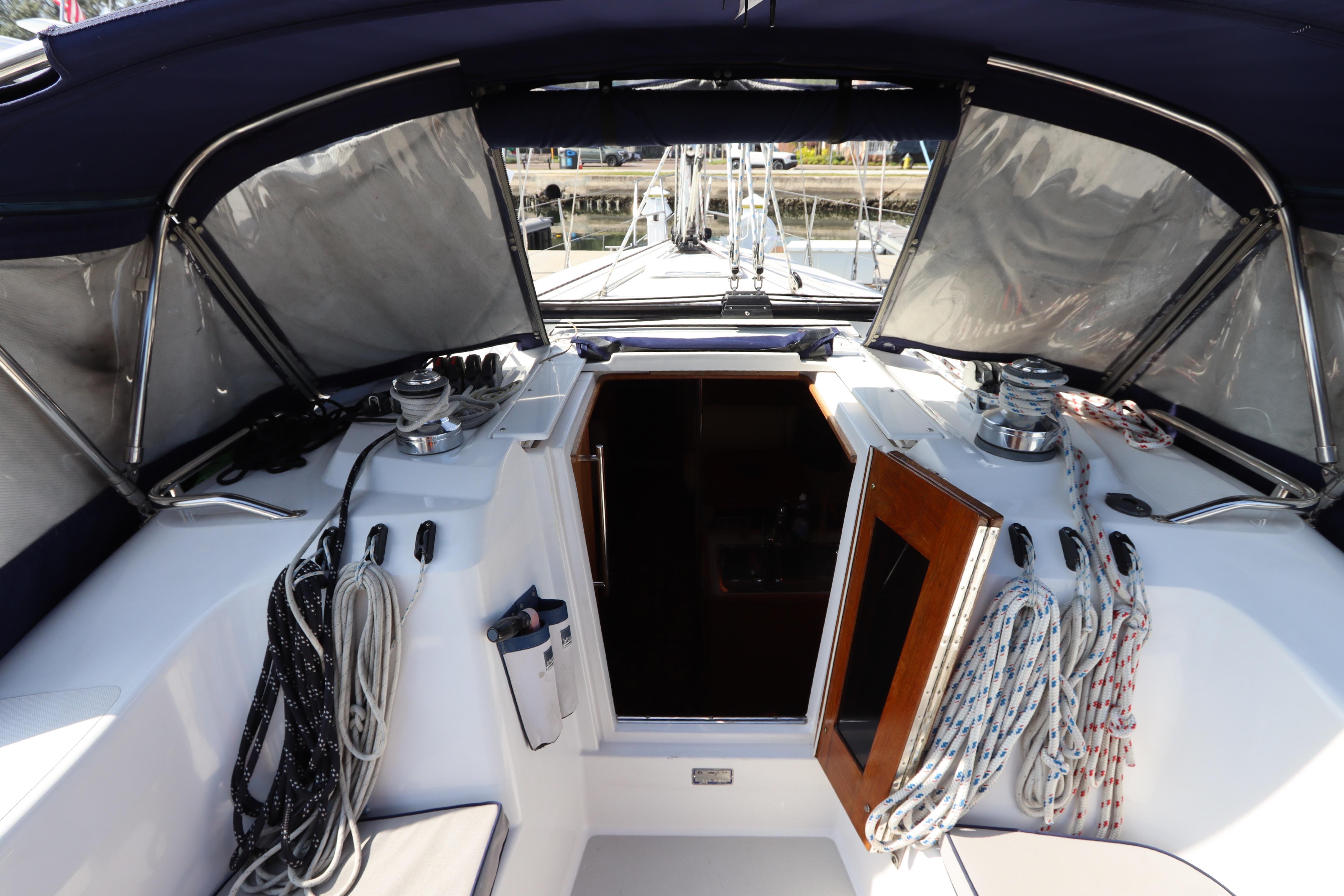 Cockpit of 2011 Catalina 355 sailboat with ropes and open cabin door.