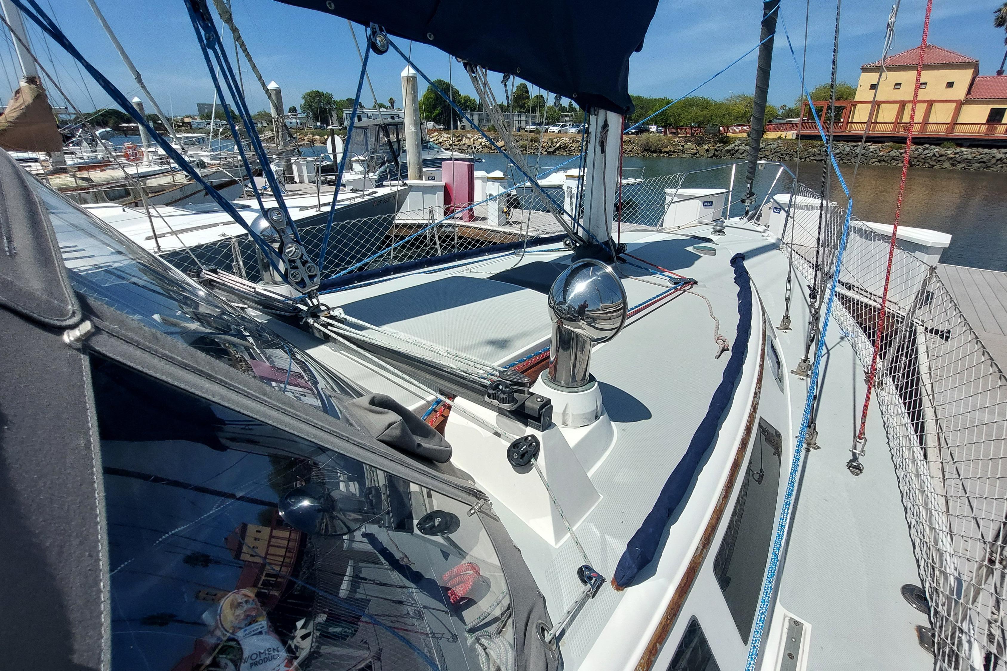 1989 Catalina 34 sailboat docked at marina, showcasing deck and rigging.