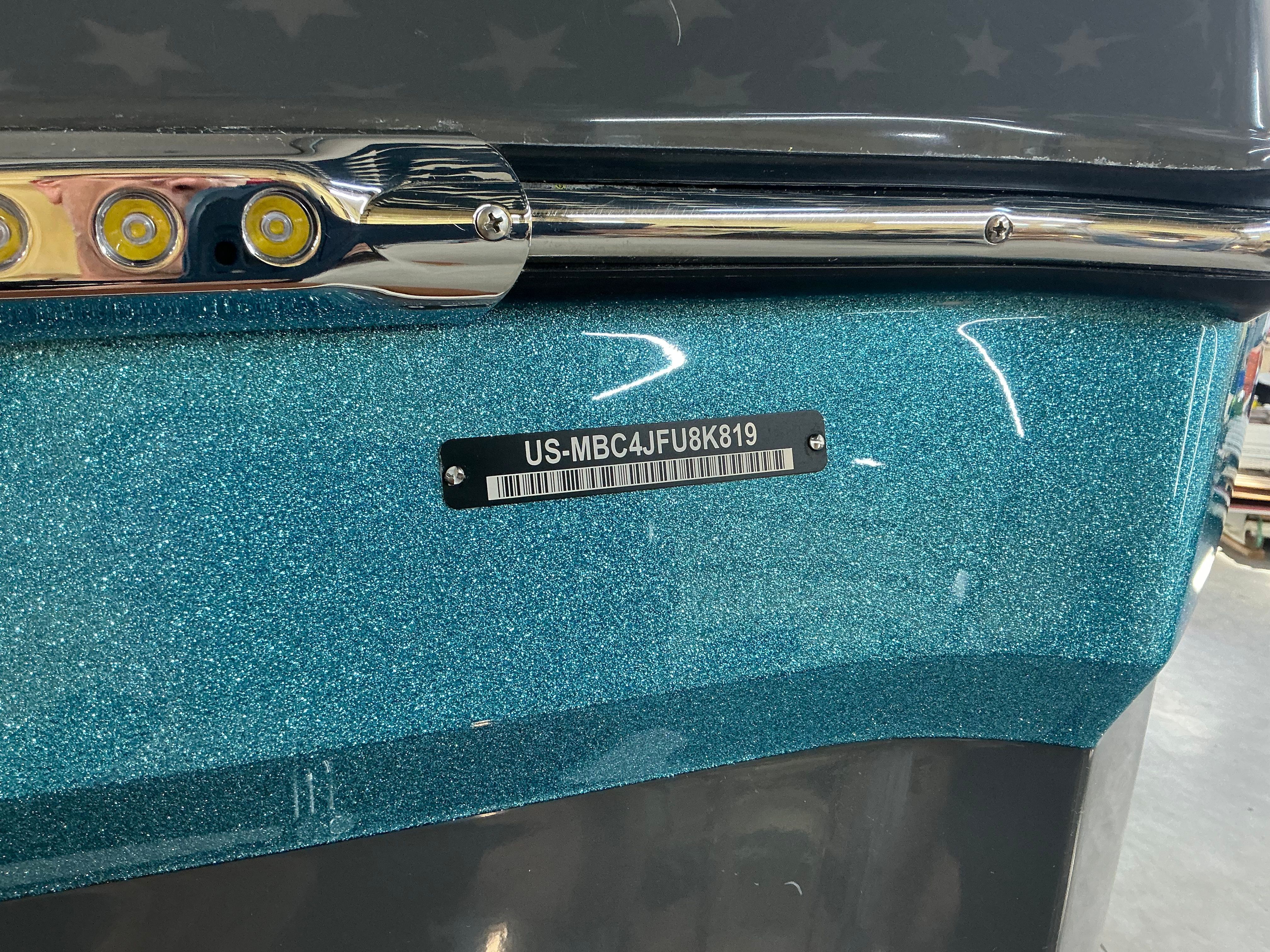 Close-up of a shiny blue hull of a 2019 MasterCraft XT22 boat.