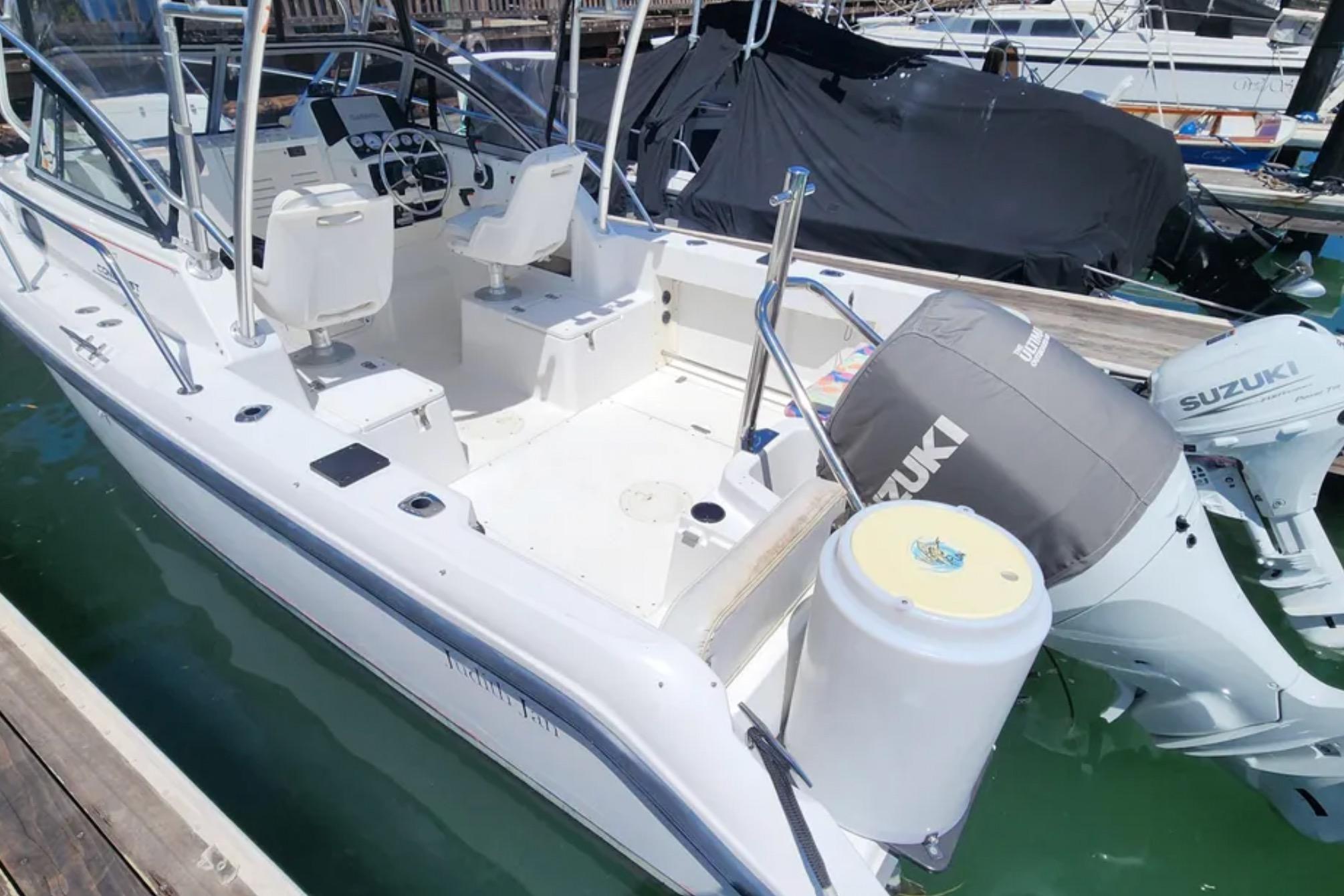 2000 Boston Whaler 21 Conquest boat with Suzuki outboard motor docked at marina.
