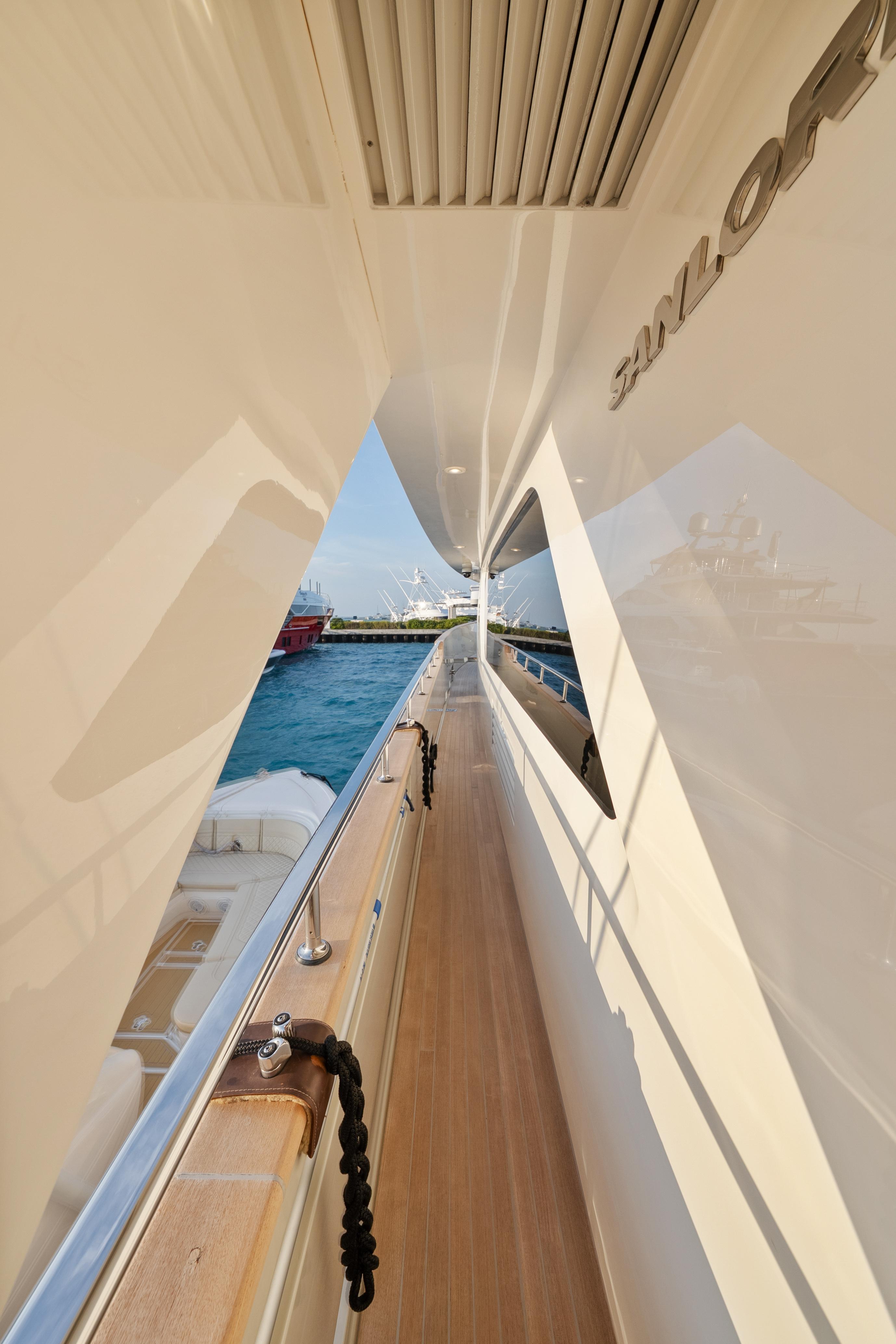 Side deck view of 2012 Sanlorenzo SD92 yacht, showcasing sleek design and ocean backdrop.