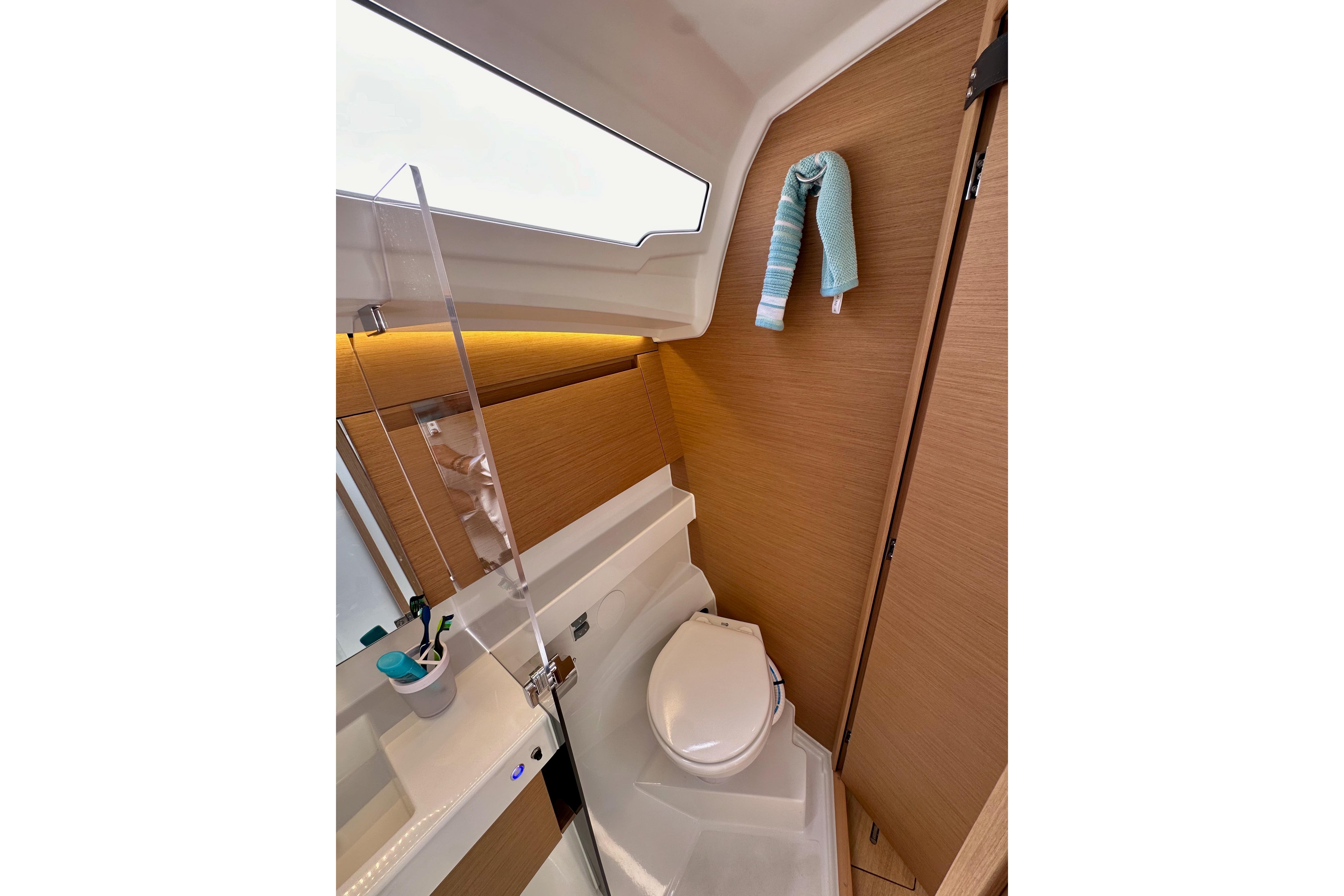 2024 Jeanneau Sun Odyssey 410 bathroom with modern fixtures and wooden accents.