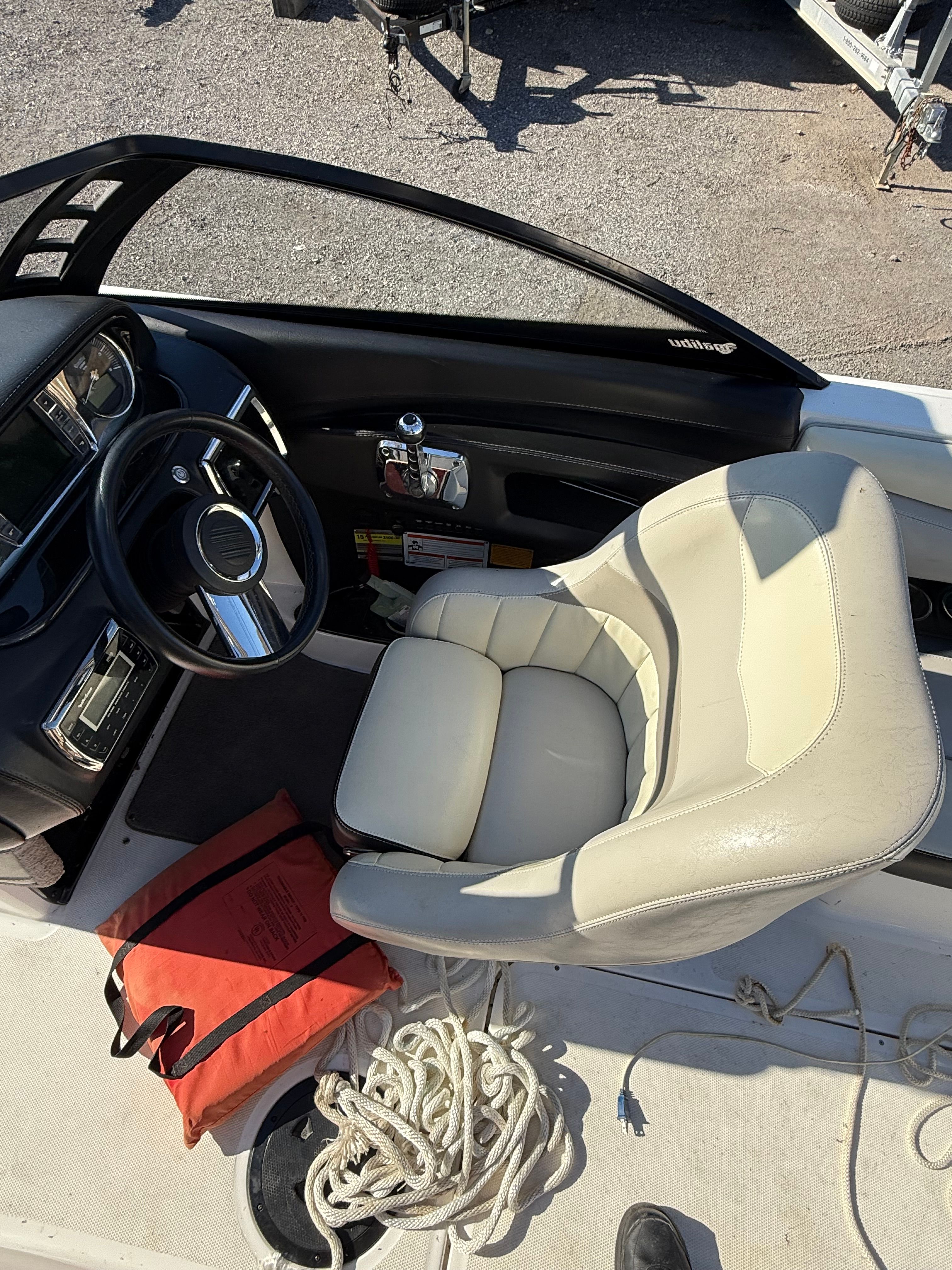 Interior of a Malibu Wakesetter 22 MXZ with beige seat and steering wheel.
