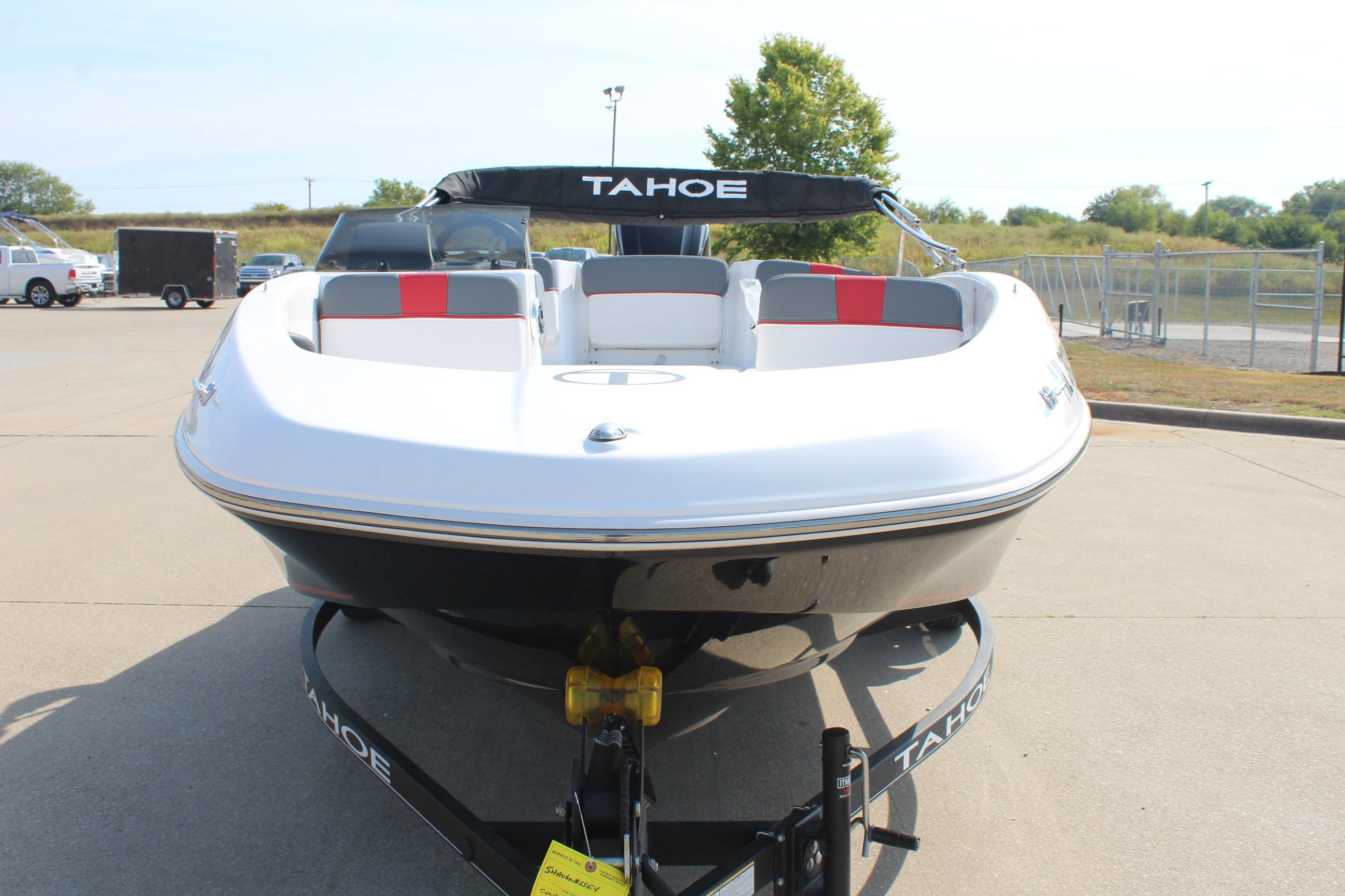 2023 Tahoe T16 boat on trailer, white and black design, parked outdoors.