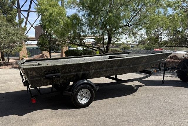 2026 Tracker Grizzly 1754 Utility boat on trailer, parked outdoors under trees.
