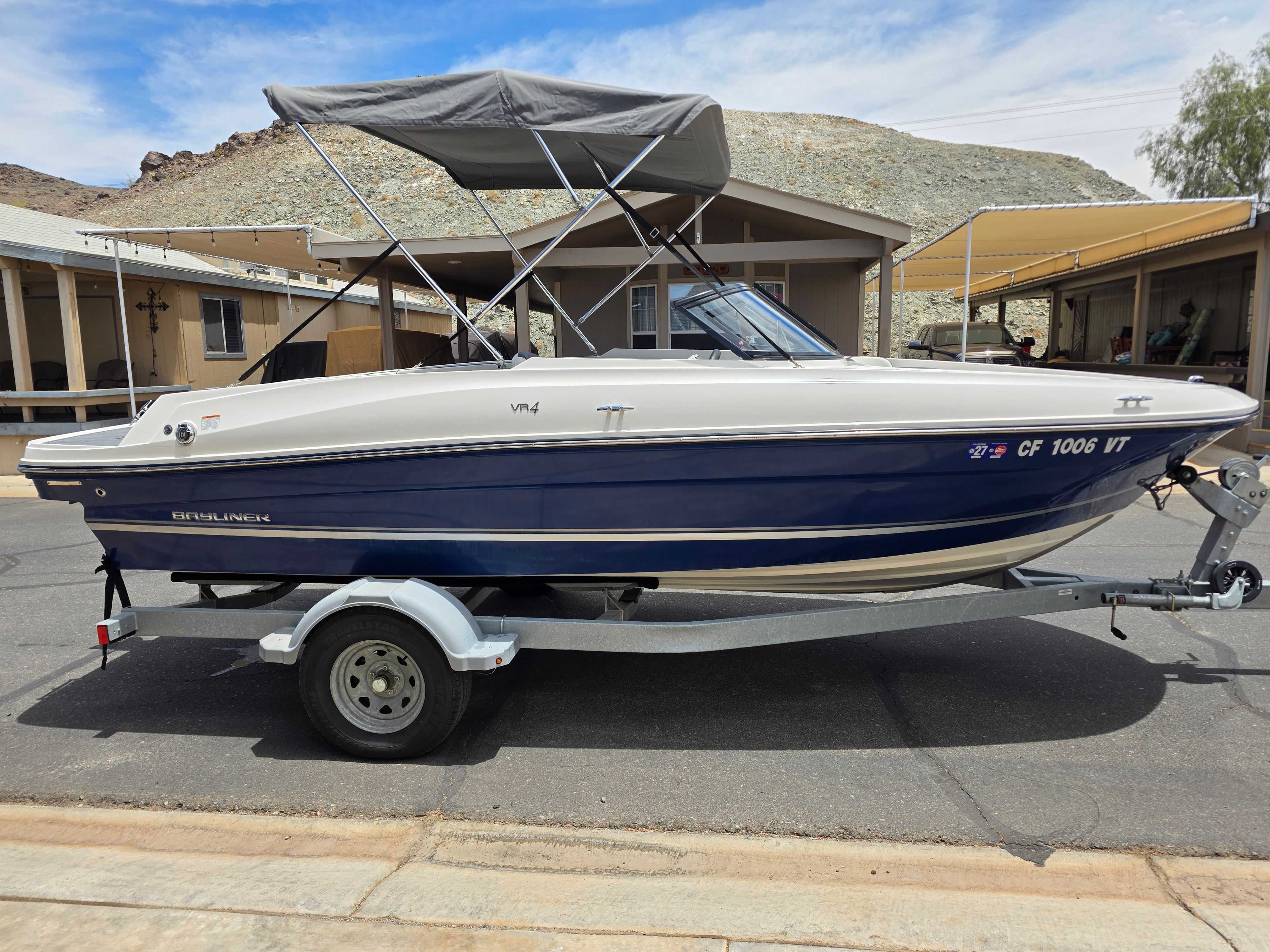 2021 Bayliner VR4 Bowrider I/O on a trailer, featuring a blue hull and gray bimini top.