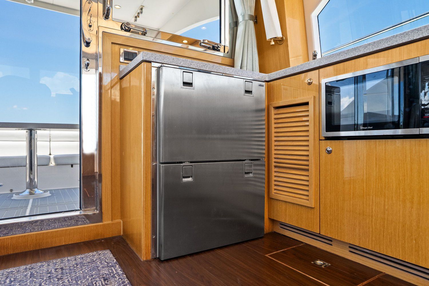 Interior of a modern yacht with stainless steel fridge and microwave.