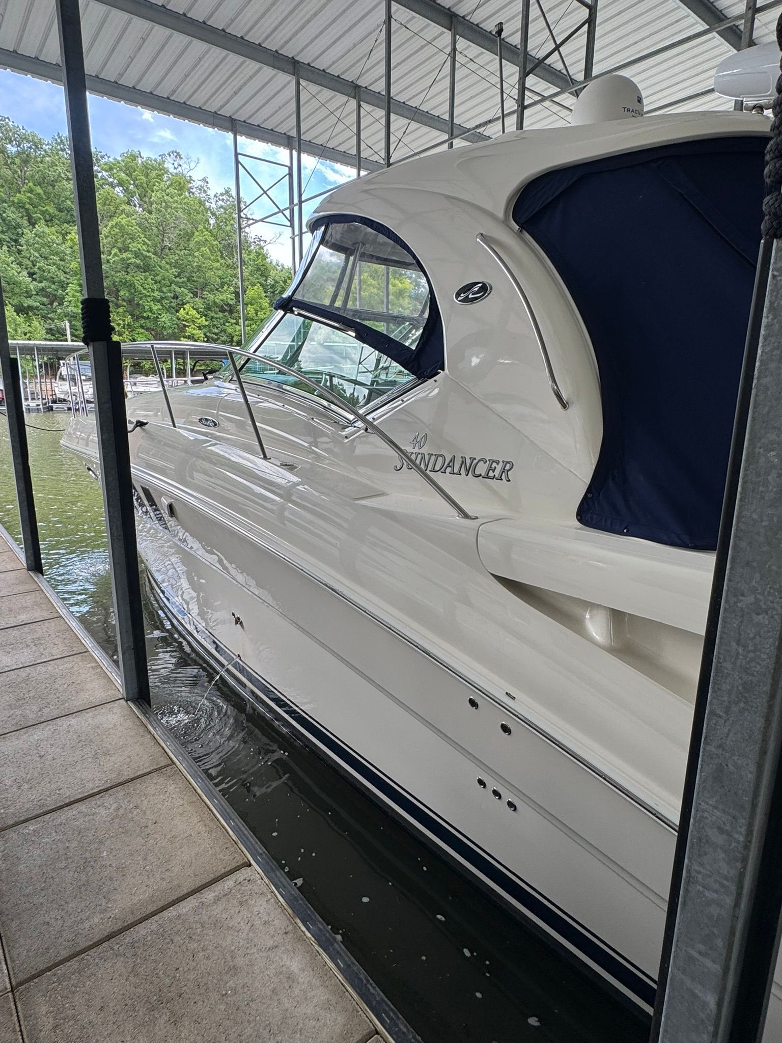 A 2007 Sea Ray 40 Sundancer is docked under a covered area.