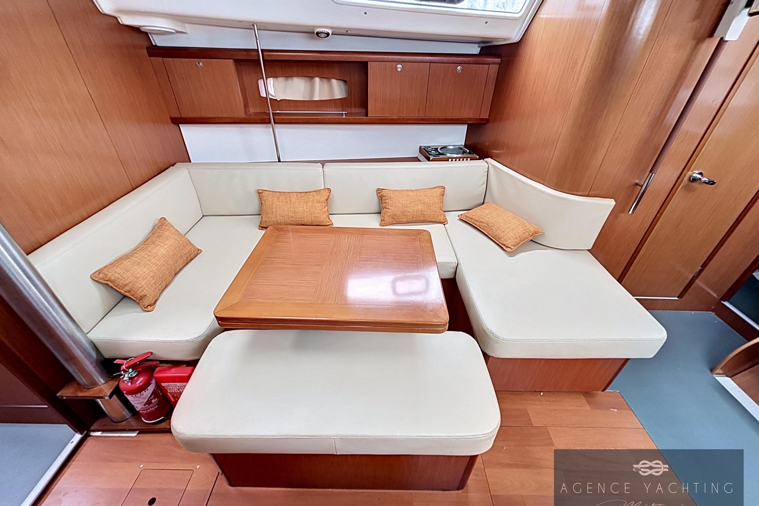 Interior of 2008 Beneteau Oceanis 40 yacht with cozy seating and wooden table.