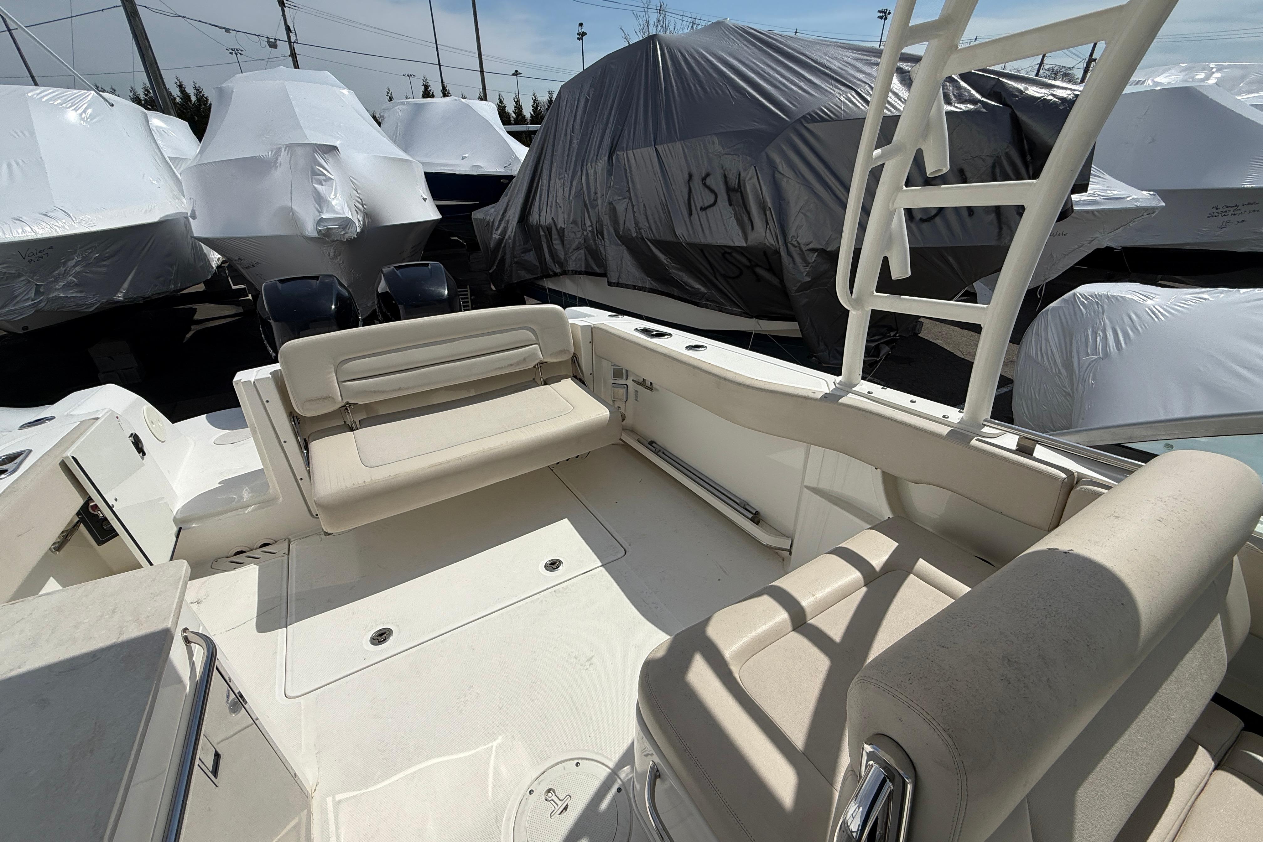 2016 Boston Whaler 270 Vantage boat interior with seating, docked among covered boats.